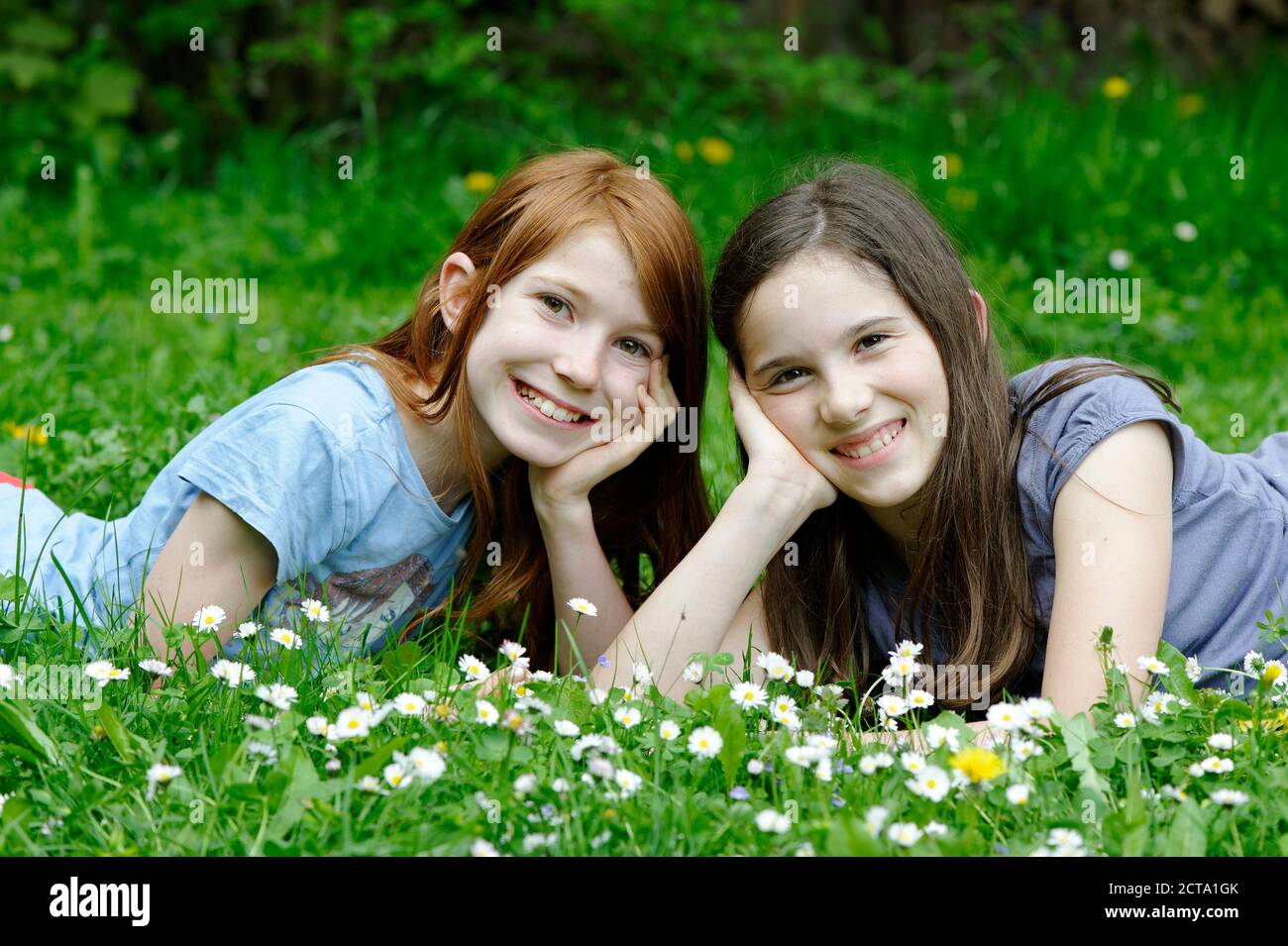 Les filles sont couché dans une prairie de fleurs Banque D'Images