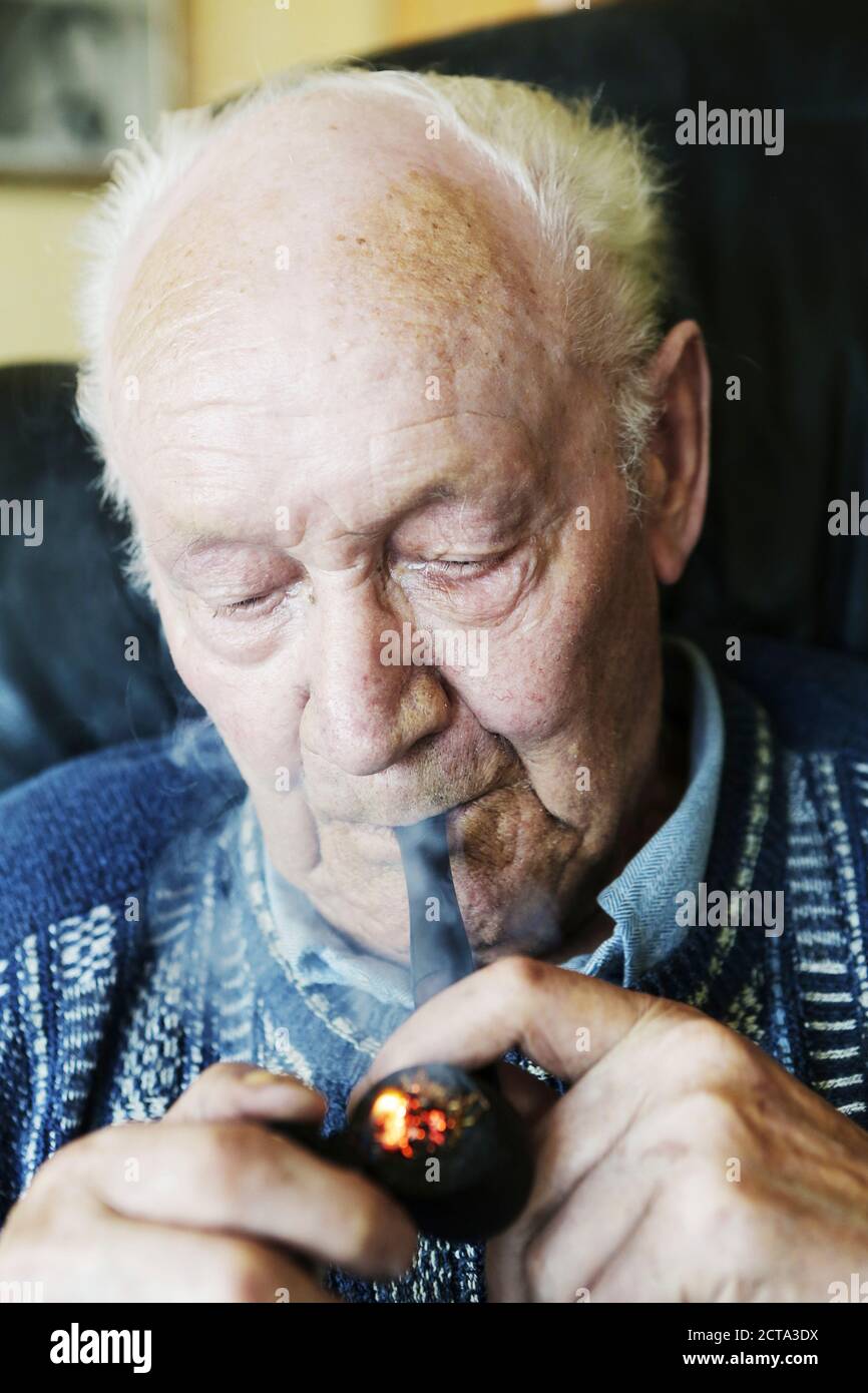 Allemagne, Senior man holding pipe, Close up Banque D'Images