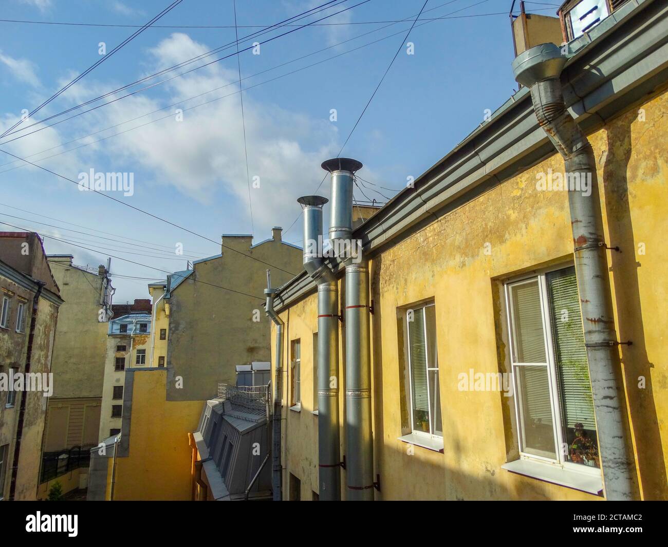 La vue de la fenêtre sur la cour avec de vieilles maisons en ruine, peintes en jaune. Banque D'Images