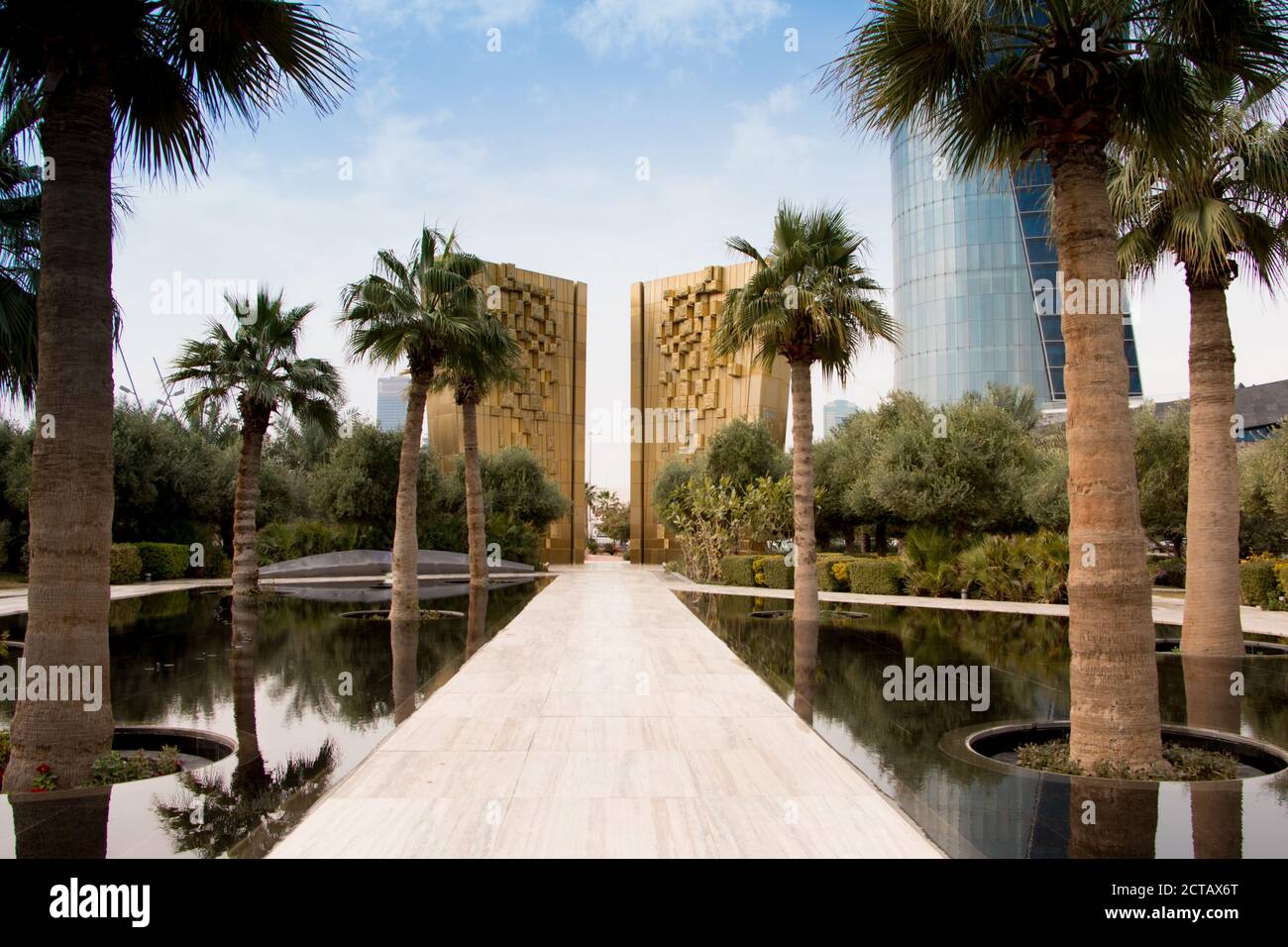 Le monument d'or pour célébrer le jubilé de la Constitution du Koweït avec palmarbres et fontaine d'eau devant. Parc Al Shaheed, Koweït. Banque D'Images
