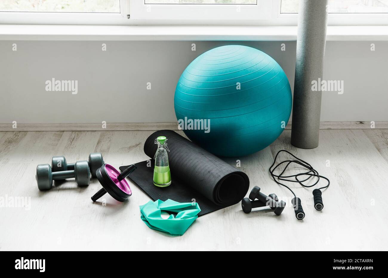 Vide moderne blanc lumineux salle avec équipement d'entraînement à la maison. Balle de yoga, bande de latex d'exercice de résistance, rouleau de mousse, poids, corde de saut, wa Banque D'Images