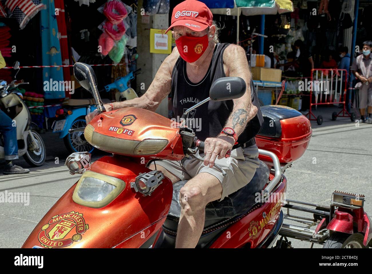 Fan de football de Manchester United, âgé, à moto et orné avec ses équipes regalia Banque D'Images