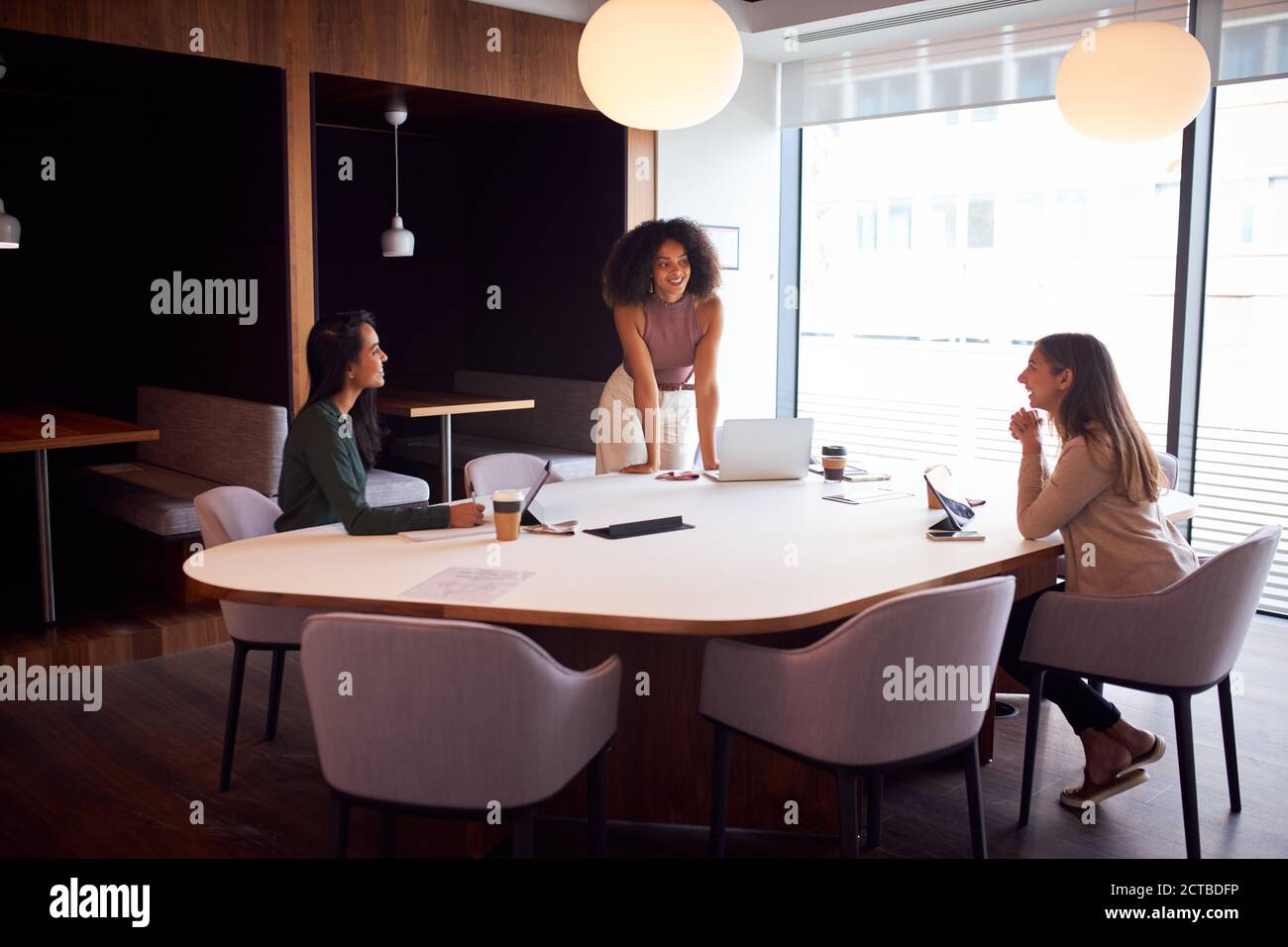 Trois femmes d'affaires ayant socialement distancé la réunion au bureau pendant la santé Pandémie Banque D'Images
