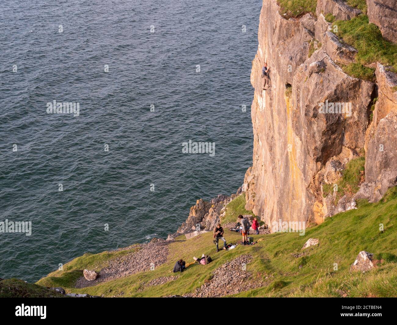 Les personnes grimpant sur les rochers à Rhossill Bay Gower Peninsula Wales ROYAUME-UNI Banque D'Images