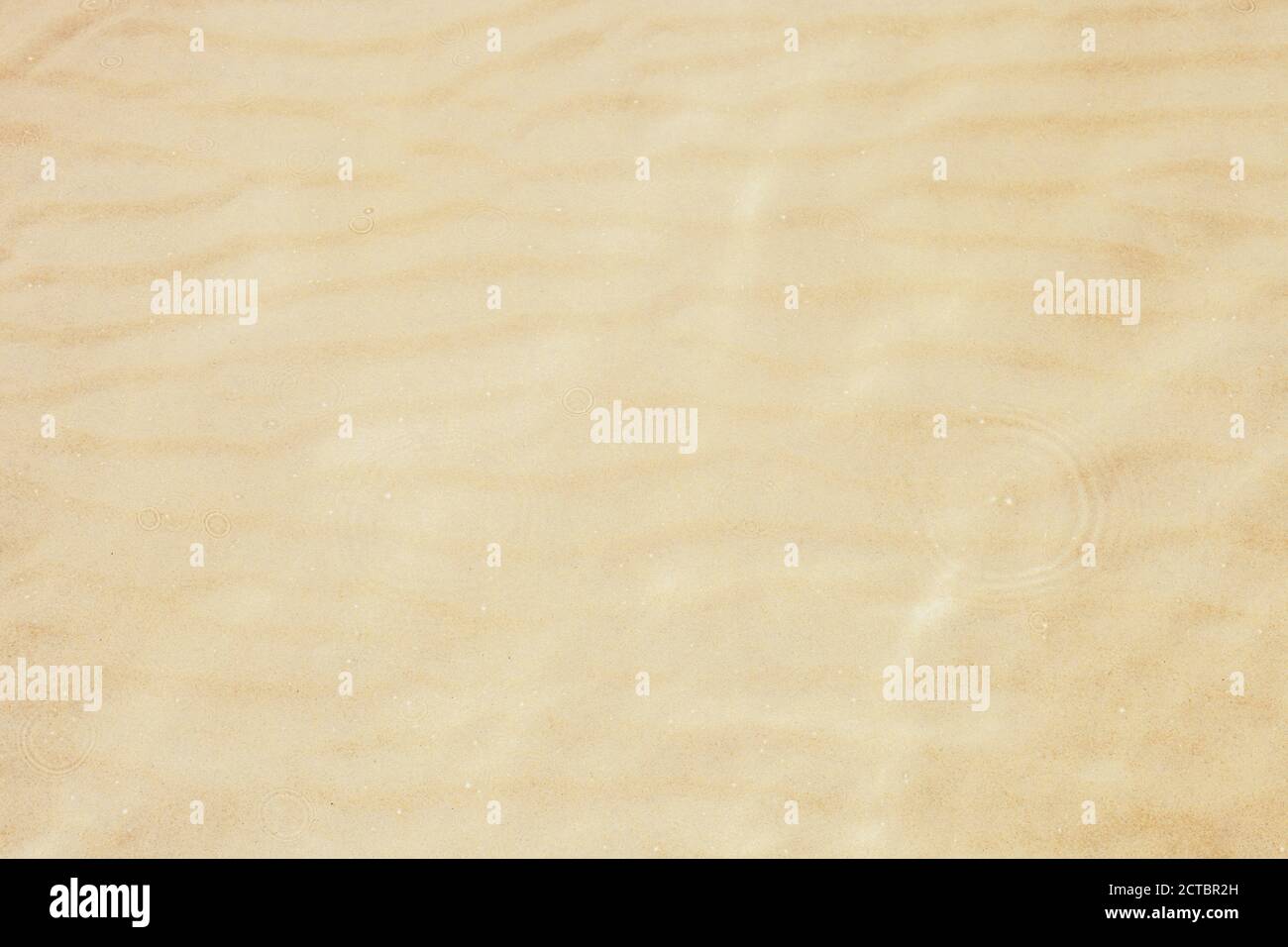 Texture de sable jaune en mer. Fond de mer sablonneux et cercles concentriques sur fond d'eau claire vue de dessus Banque D'Images