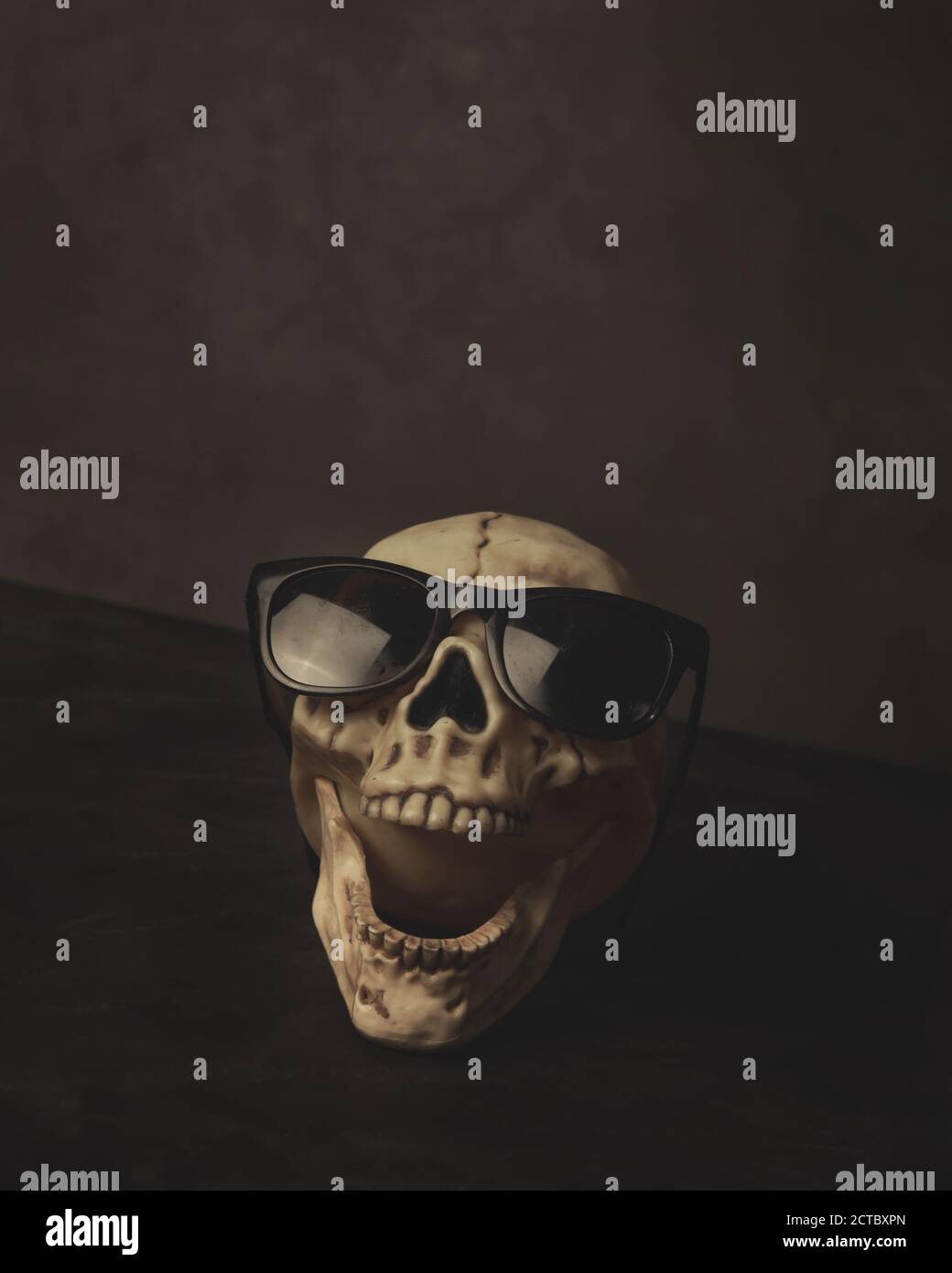 Une tête de crâne de skelton effrayante rie avec des lunettes de soleil noires sur pour un concept de peur. Banque D'Images