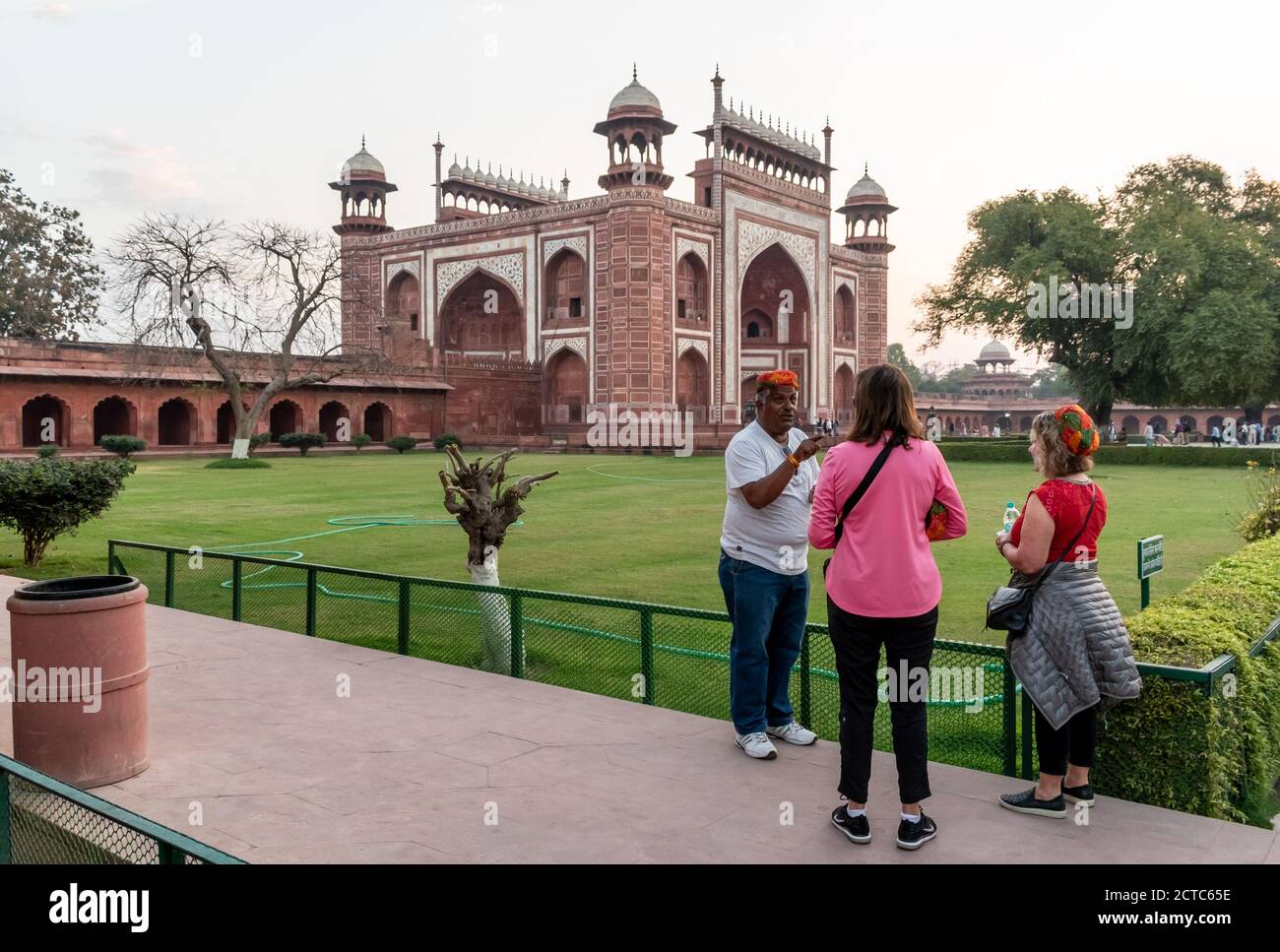 Agra, Uttar Pradesh, Inde - Mars 2019: Un guide touristique avec deux touristes européens à visiter l'ancien Taj Mahal. Banque D'Images