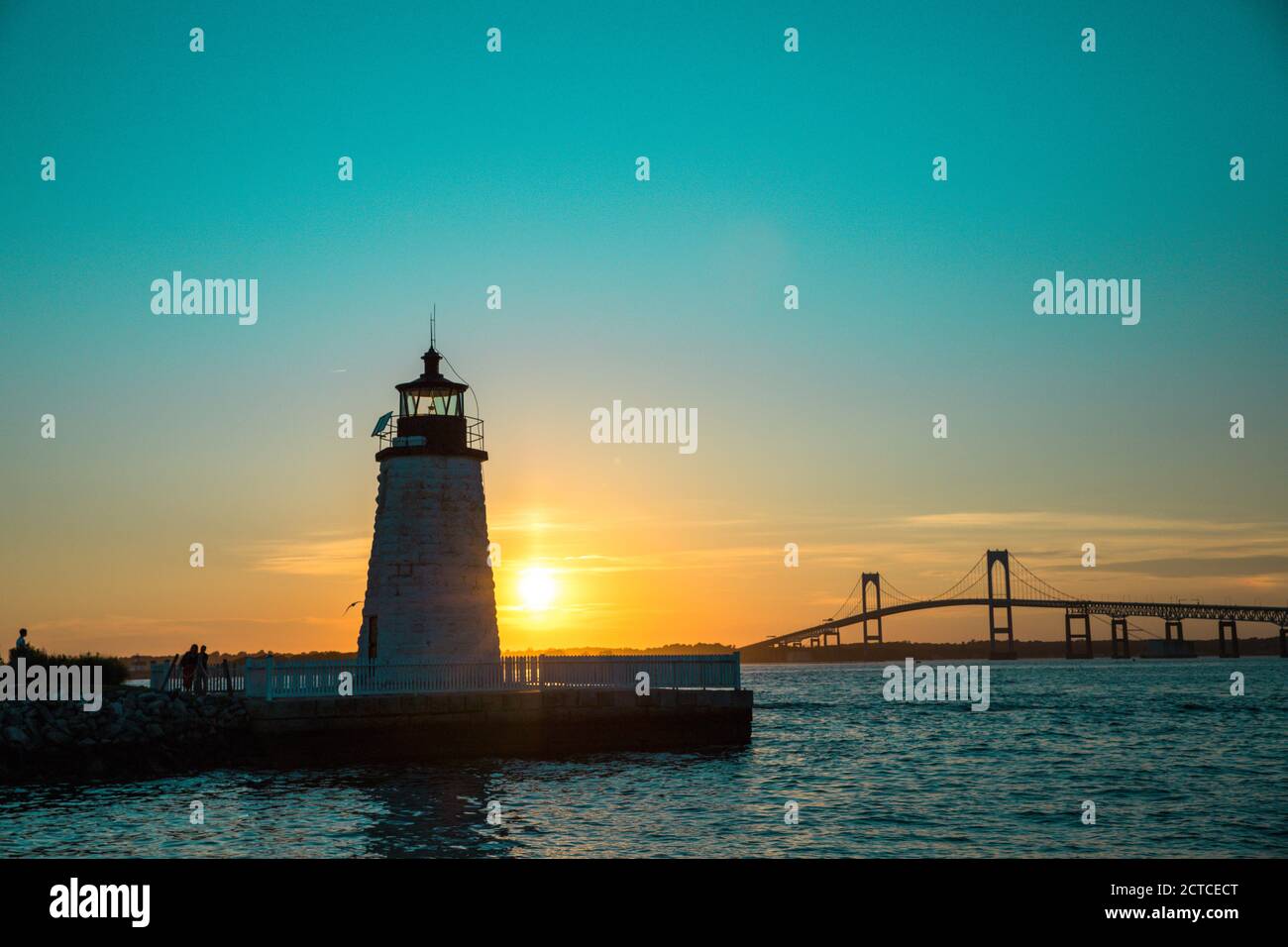 Coucher de soleil sur le phare de Newport Harbor avec pont et ciel coloré Banque D'Images