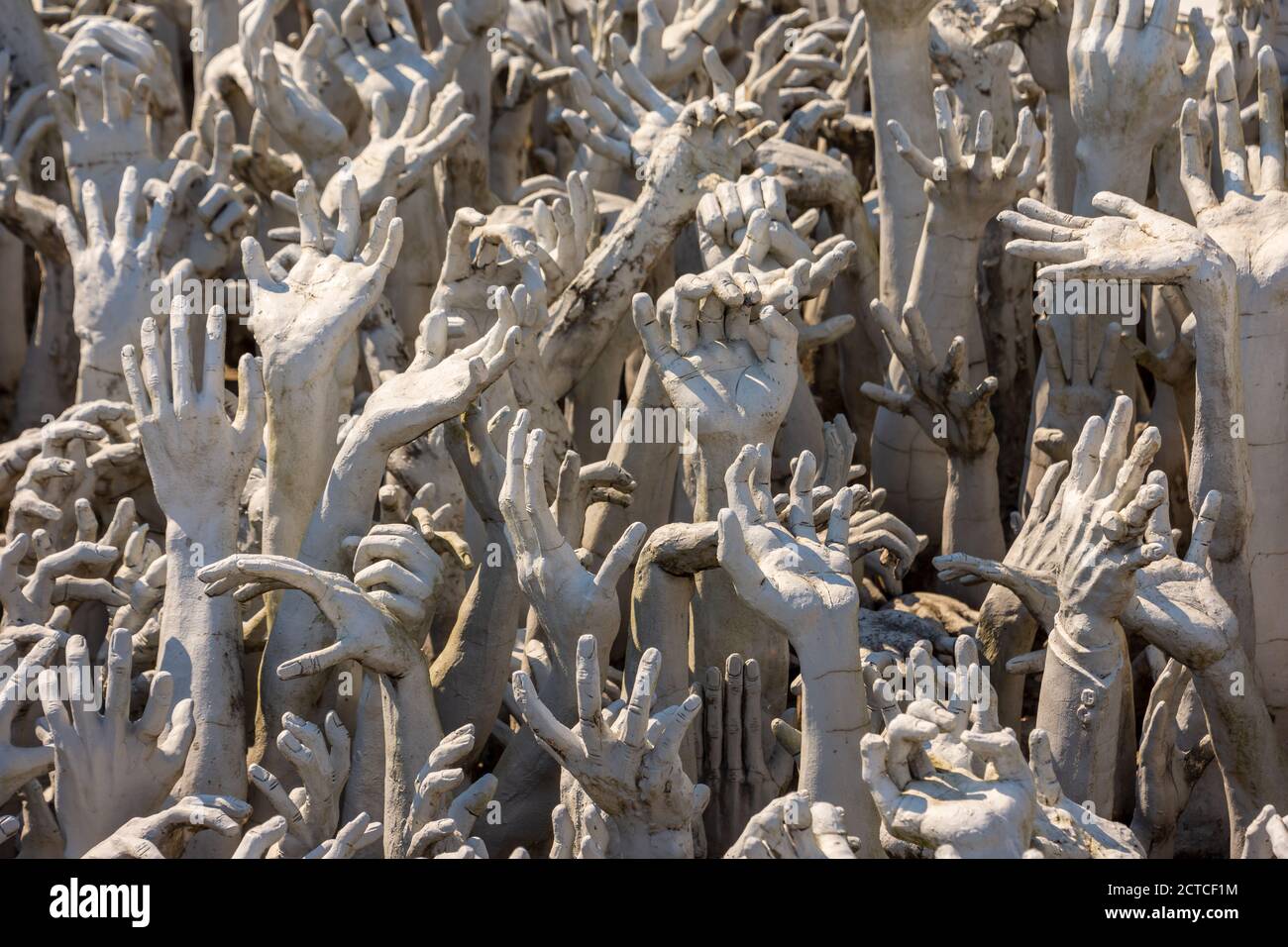 Une vue rapprochée des mains qui s'approchent de l'enfer au Temple blanc (Wat Rong Khun) à Chiang Rai, en Thaïlande. Banque D'Images