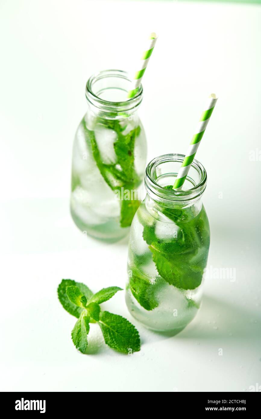 Boisson d'été, limonade fraîche à la menthe et glace dans des bouteilles de verre. Eau infusée à la menthe, cocktail, boisson détox ou limonade Banque D'Images