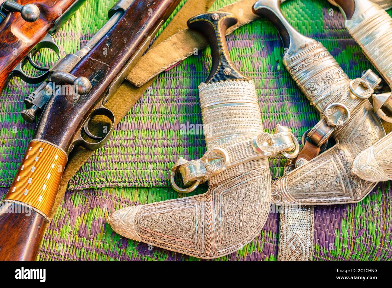 Khanjars et fusils exposés au marché du vendredi des armes à feu à Nizwa, en Oman Banque D'Images