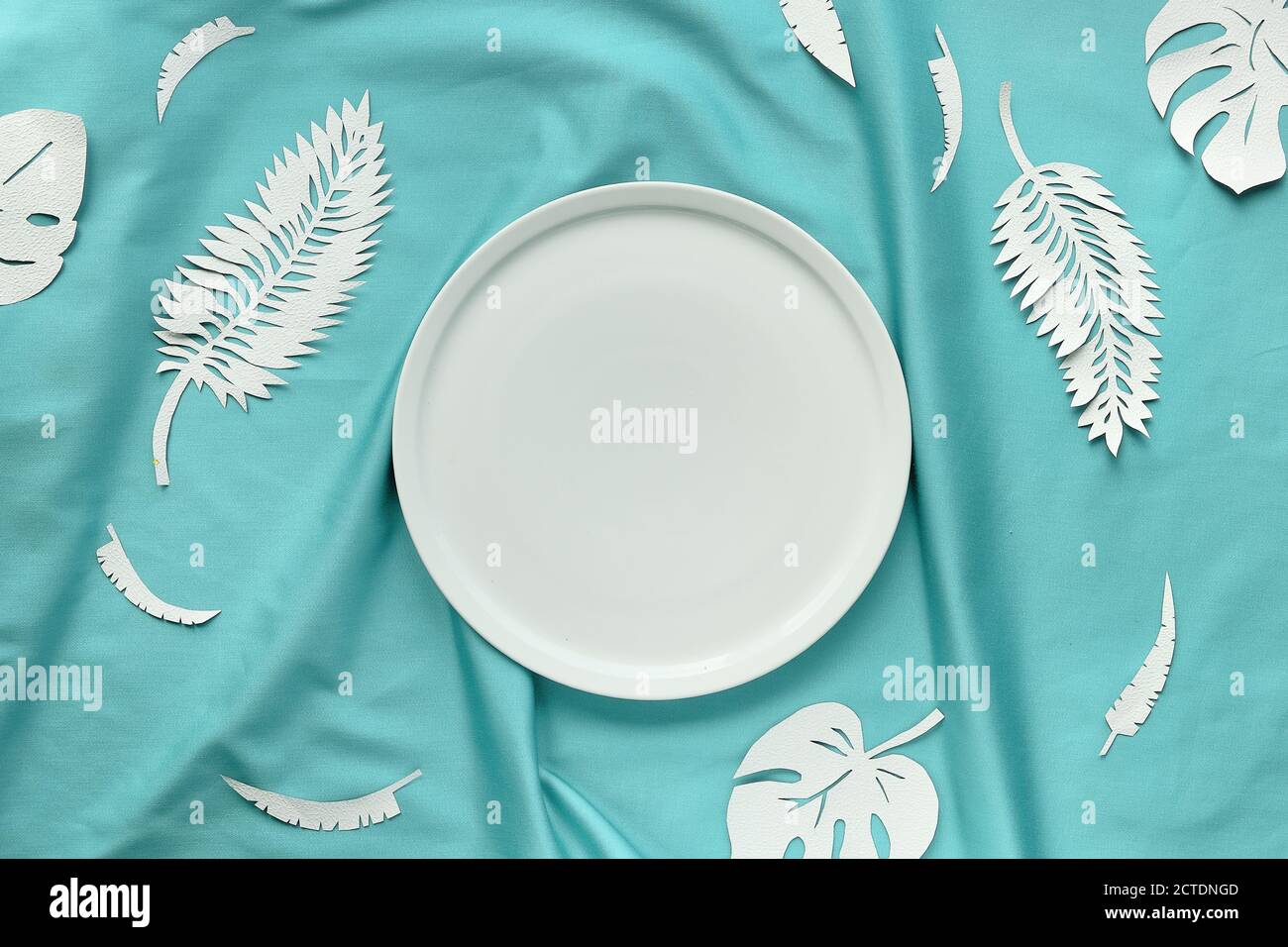 Ai Aqua - couleur tendance de 2021 ans. Vue sur le haut à la mode, feuilles de papier exotiques sur du textile. Banque D'Images