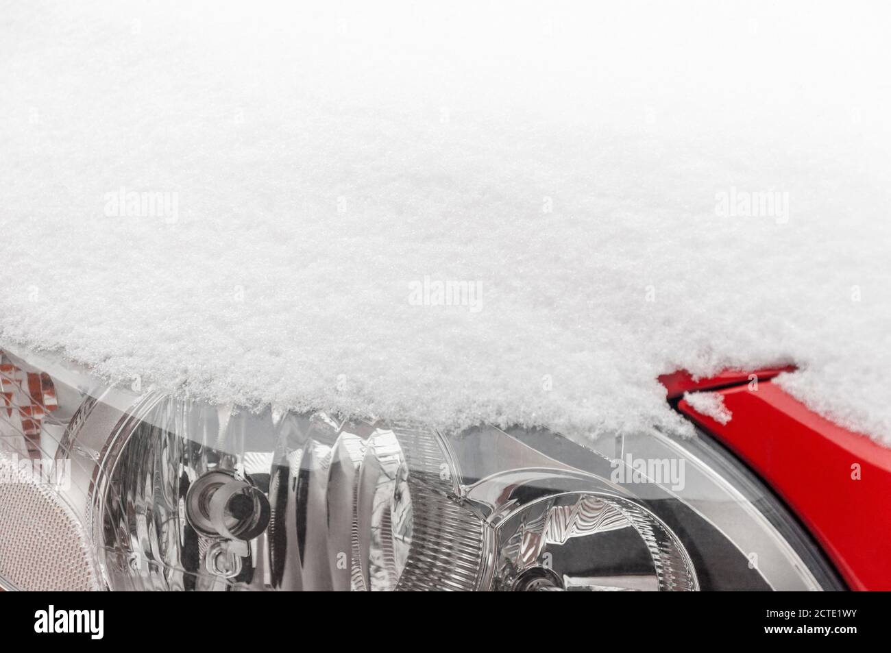 Capot et phare de voiture Volvo rouge recouverts de neige Banque D'Images