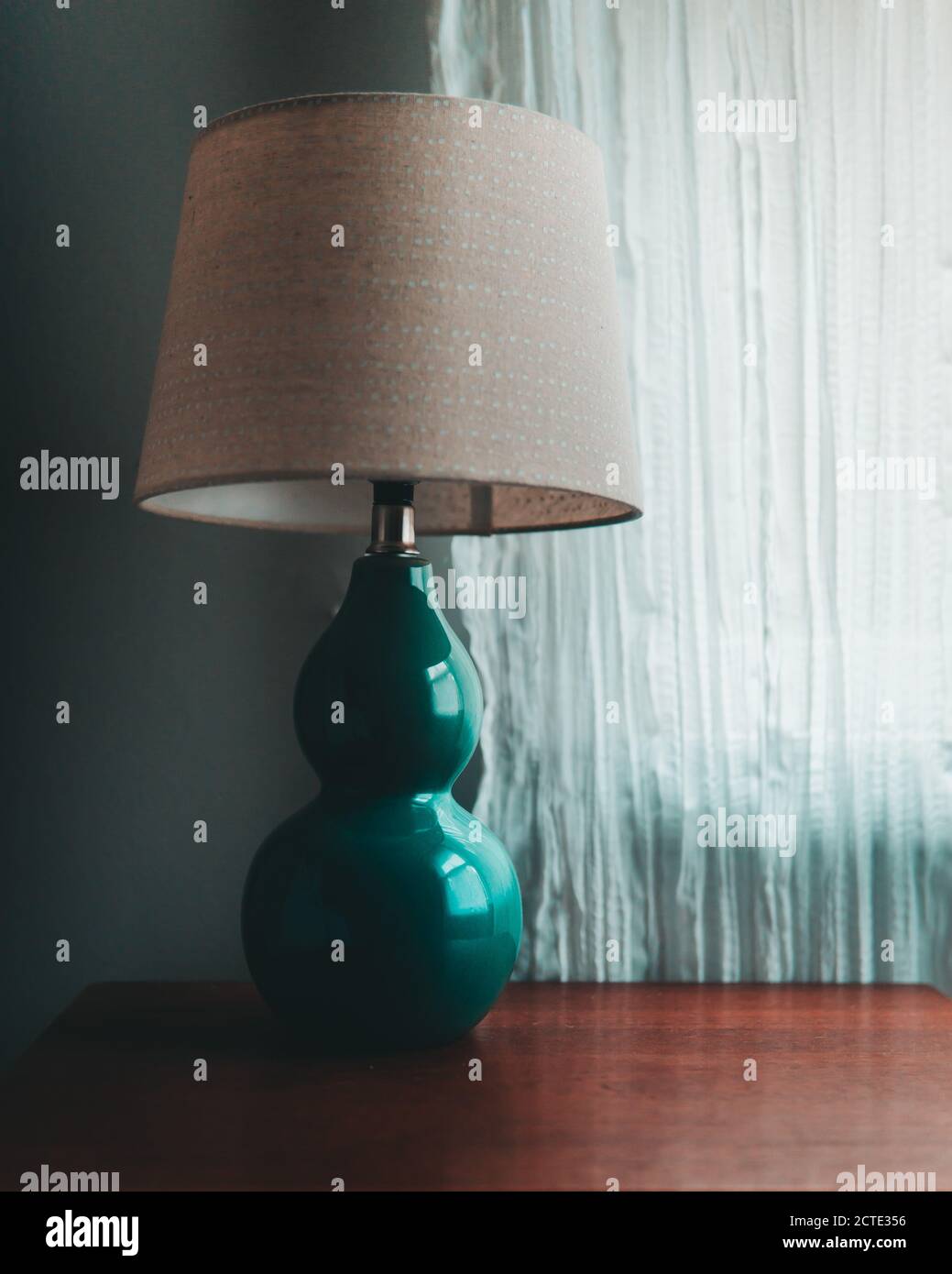 Lampe verte sur une table de nuit en bois Banque D'Images