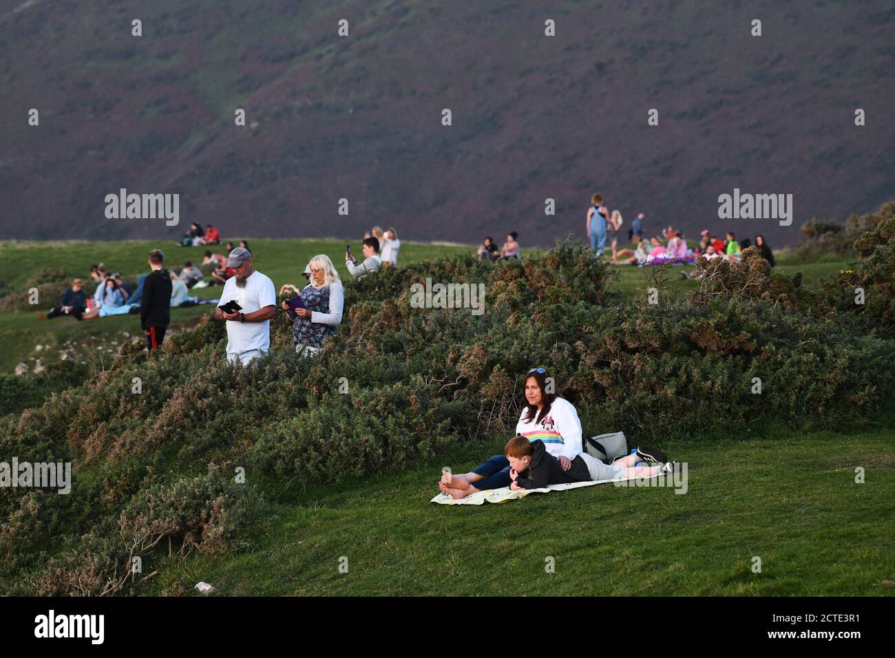 Rhossili, Gower, pays de Galles, Royaume-Uni. 21 septembre 2020 des personnes se jettent sur les falaises de la baie de Rhossili, sur la côte Gower de Swansea, pour admirer un coucher de soleil spectaculaire derrière Banque D'Images