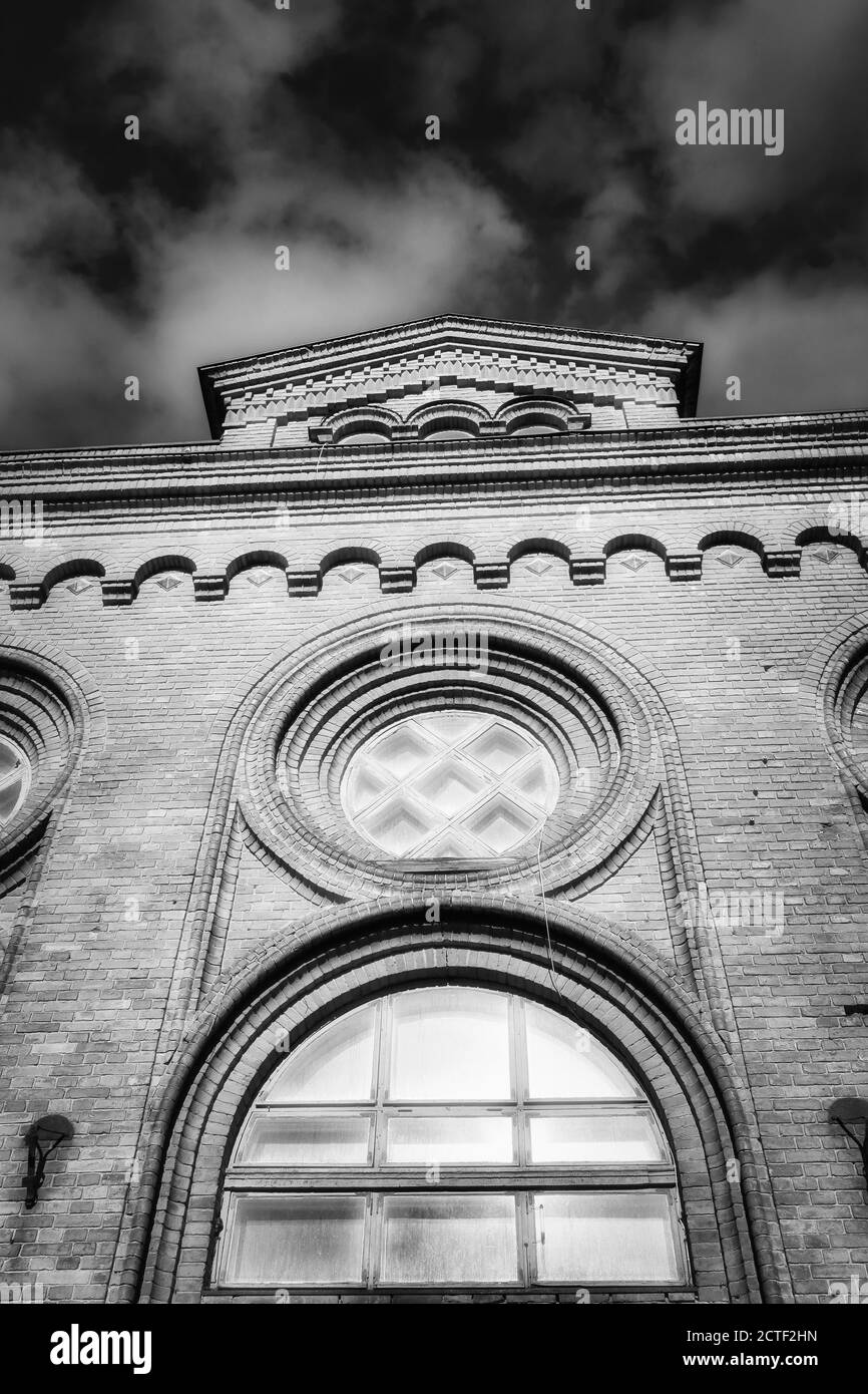 Fenêtre rose sur la façade d'un ancien bâtiment en briques. Banque D'Images