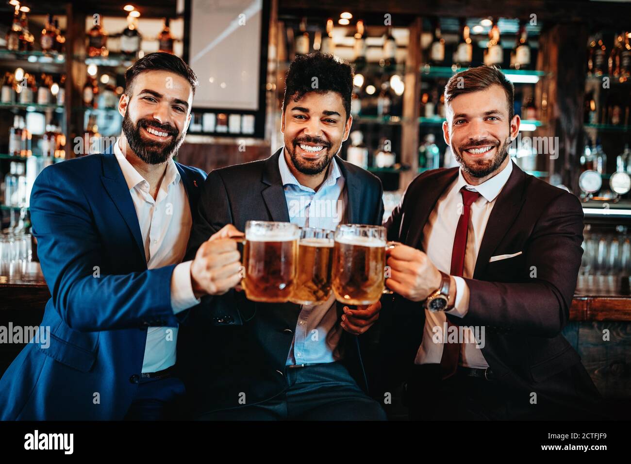 De vieux amis joyeux qui s'amusent et boivent de la bière au bar du pub. Banque D'Images