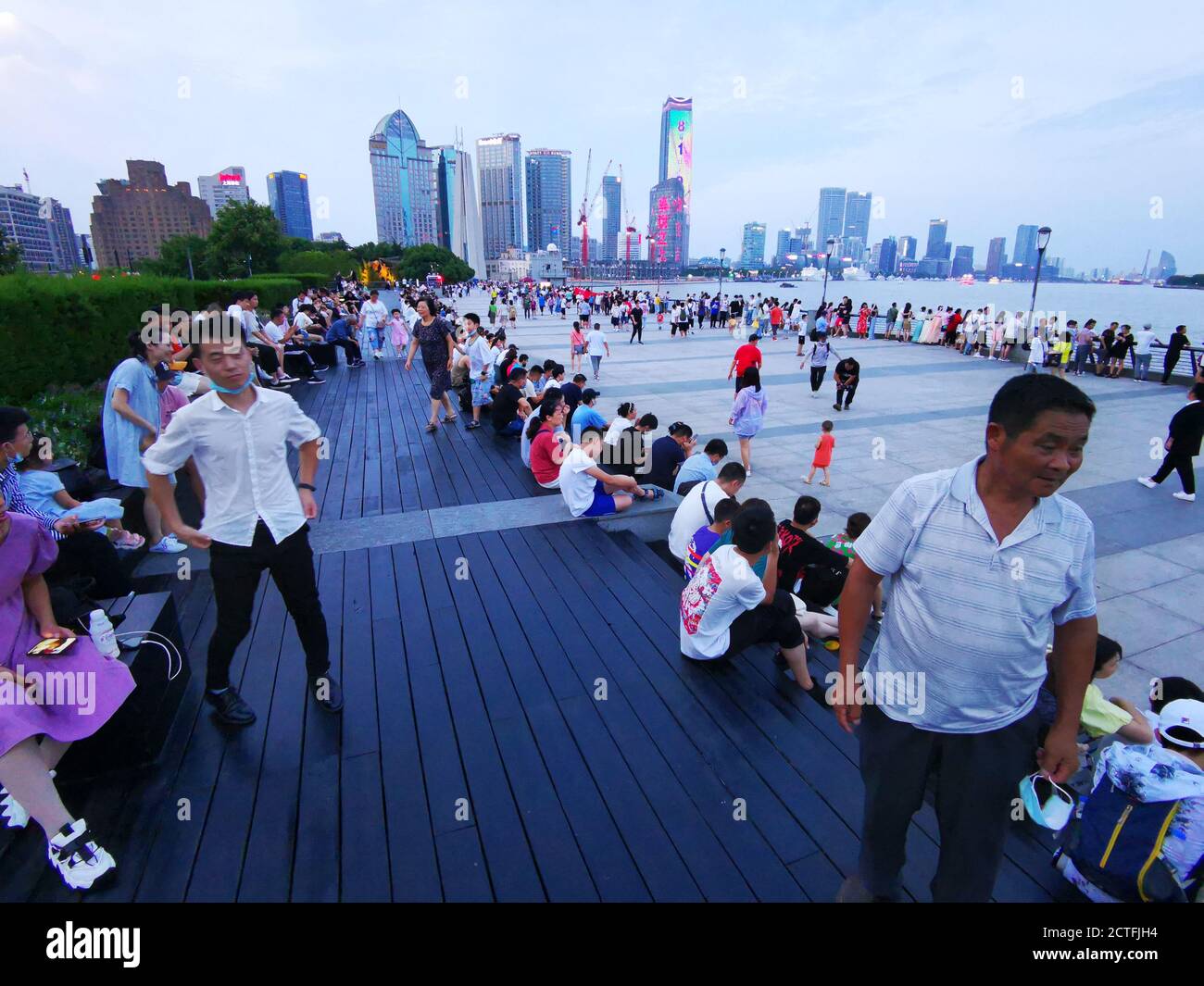 Un groupe de touristes s'assoient sur les marches au coucher du soleil, car la température était trop jour pendant la journée, pour profiter de l'horizon étonnant de Shanghai, en Chine Banque D'Images