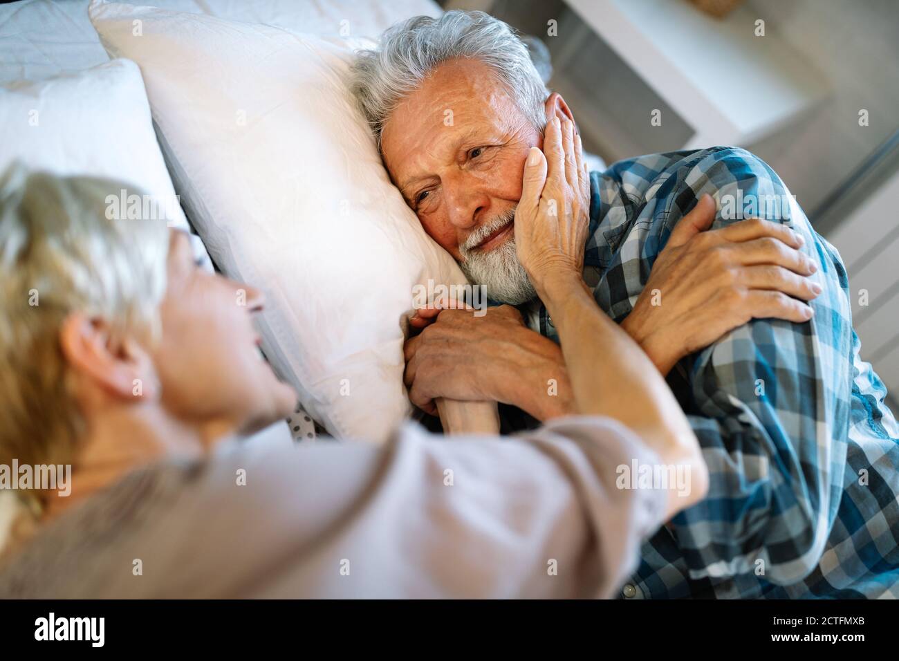 Joyeux couple senior qui s'embrasse, dormant ensemble dans la chambre Banque D'Images