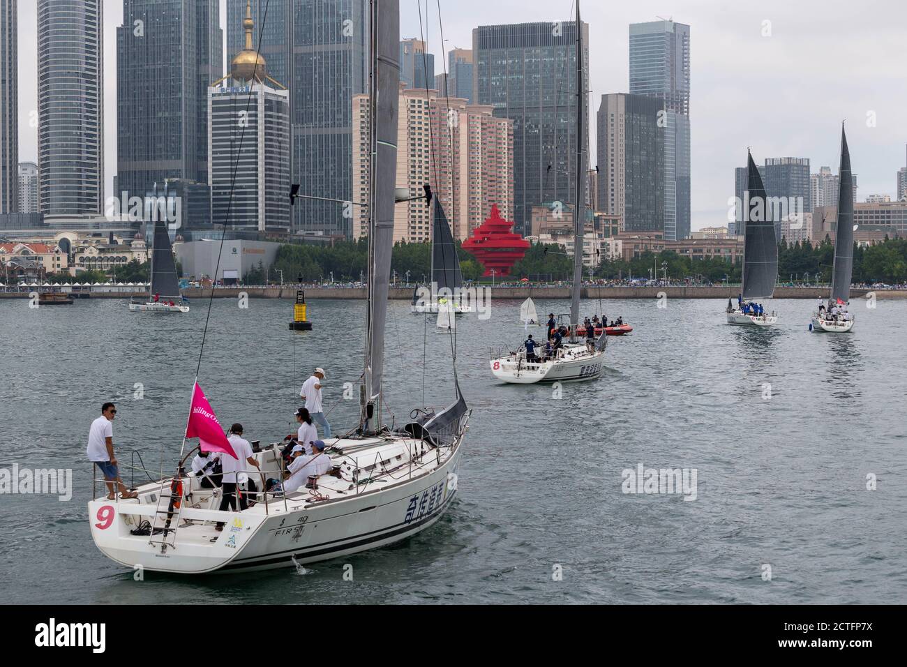 Les voiliers se déplacent sur la surface de l'eau après la cérémonie d'ouverture de la 12ème semaine internationale de la voile, ville de Qingdao, Shand de Chine orientale Banque D'Images