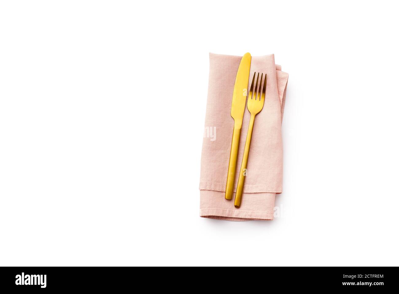 Plat avec fourchette dorée et couteau sur serviette en lin rose pliée isolée sur fond blanc. Couverts avec vue sur le dessus et espace pour les copies Banque D'Images