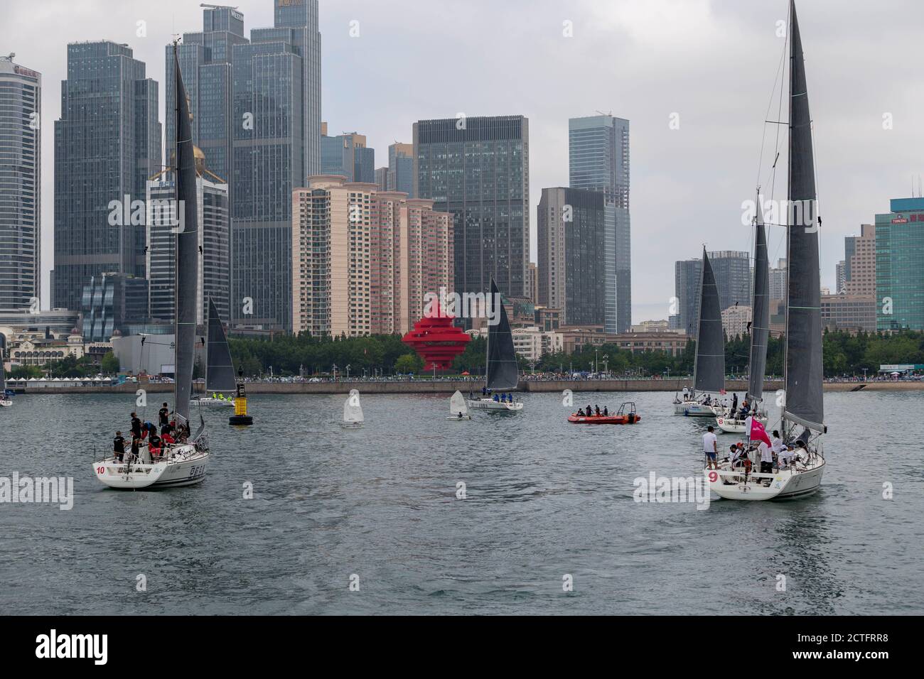 Les voiliers se déplacent sur la surface de l'eau après la cérémonie d'ouverture de la 12ème semaine internationale de la voile, ville de Qingdao, Shand de Chine orientale Banque D'Images