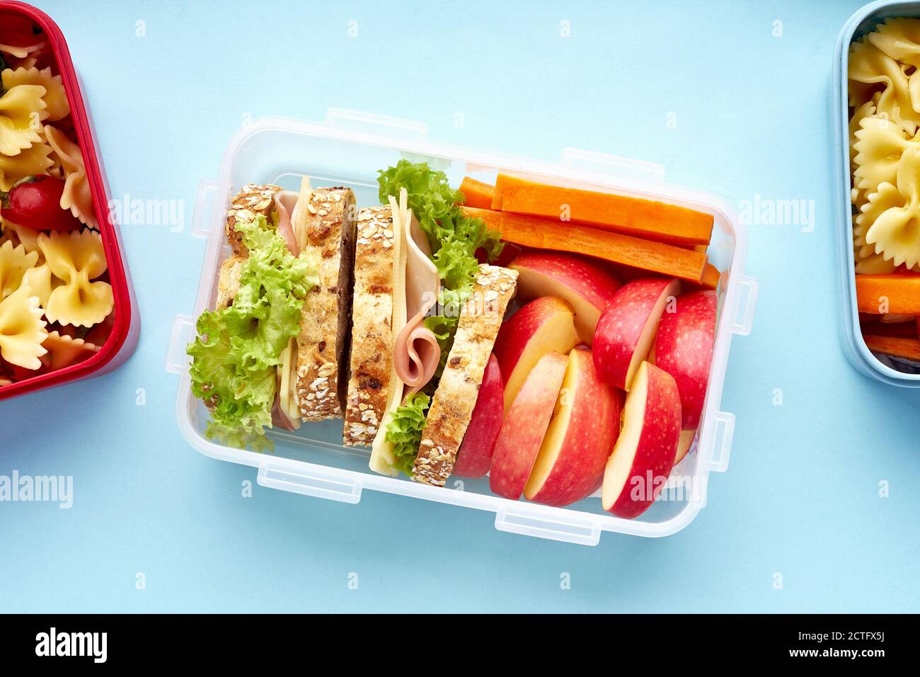 Vue de dessus des boîtes à lunch de l'école avec divers repas sains nutritifs sur fond bleu Banque D'Images