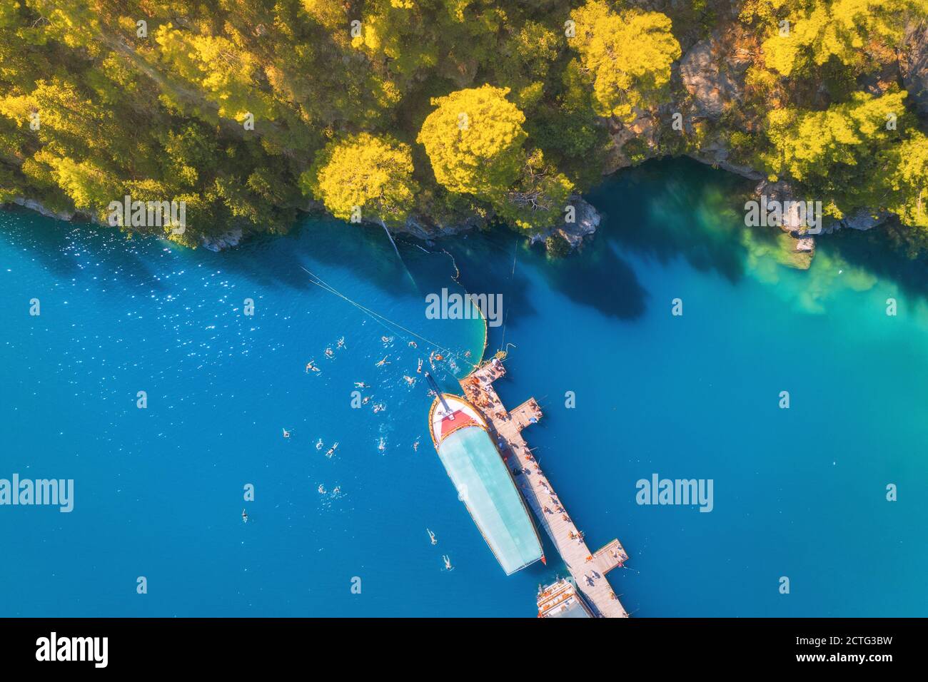 Vue aérienne sur les bateaux, jetée en bois bleu et arbres verts Banque D'Images
