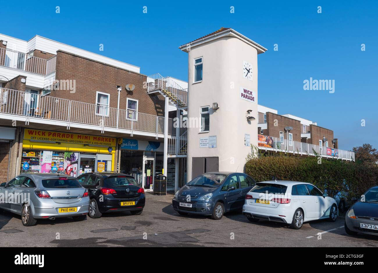 Magasins et horloge au centre commercial de Wick Parade à Wick, West Sussex, Angleterre, Royaume-Uni. Banque D'Images