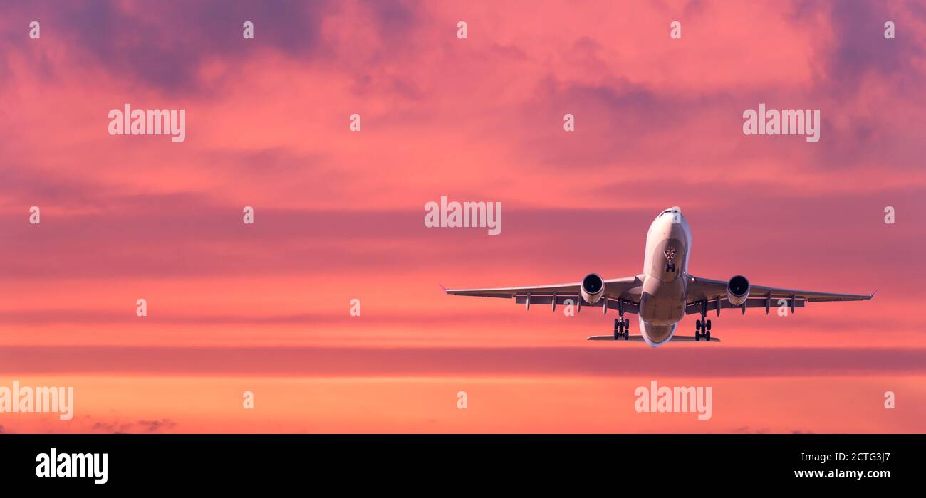 L'avion passager vole dans un ciel coloré au coucher du soleil Banque D'Images