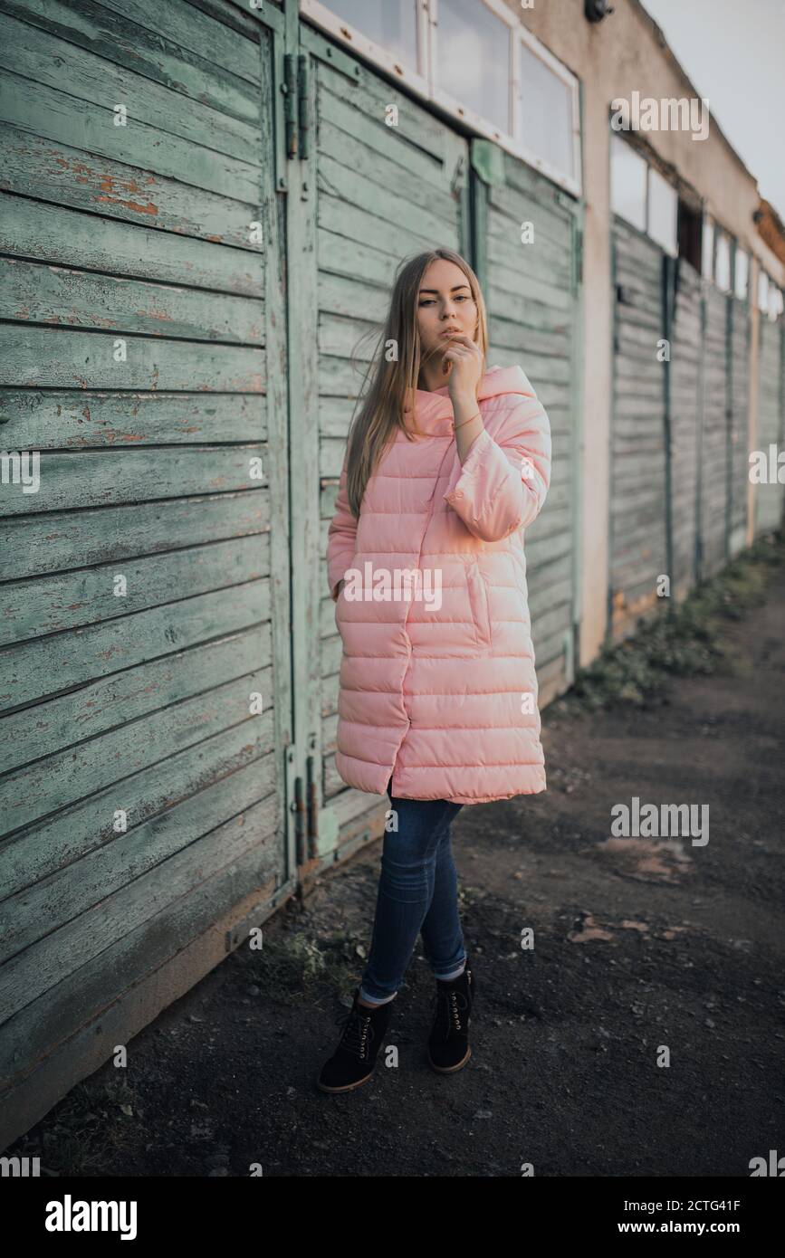 Jeune fille blonde magnifique robe de mode rose veste et bleu jeans Banque D'Images