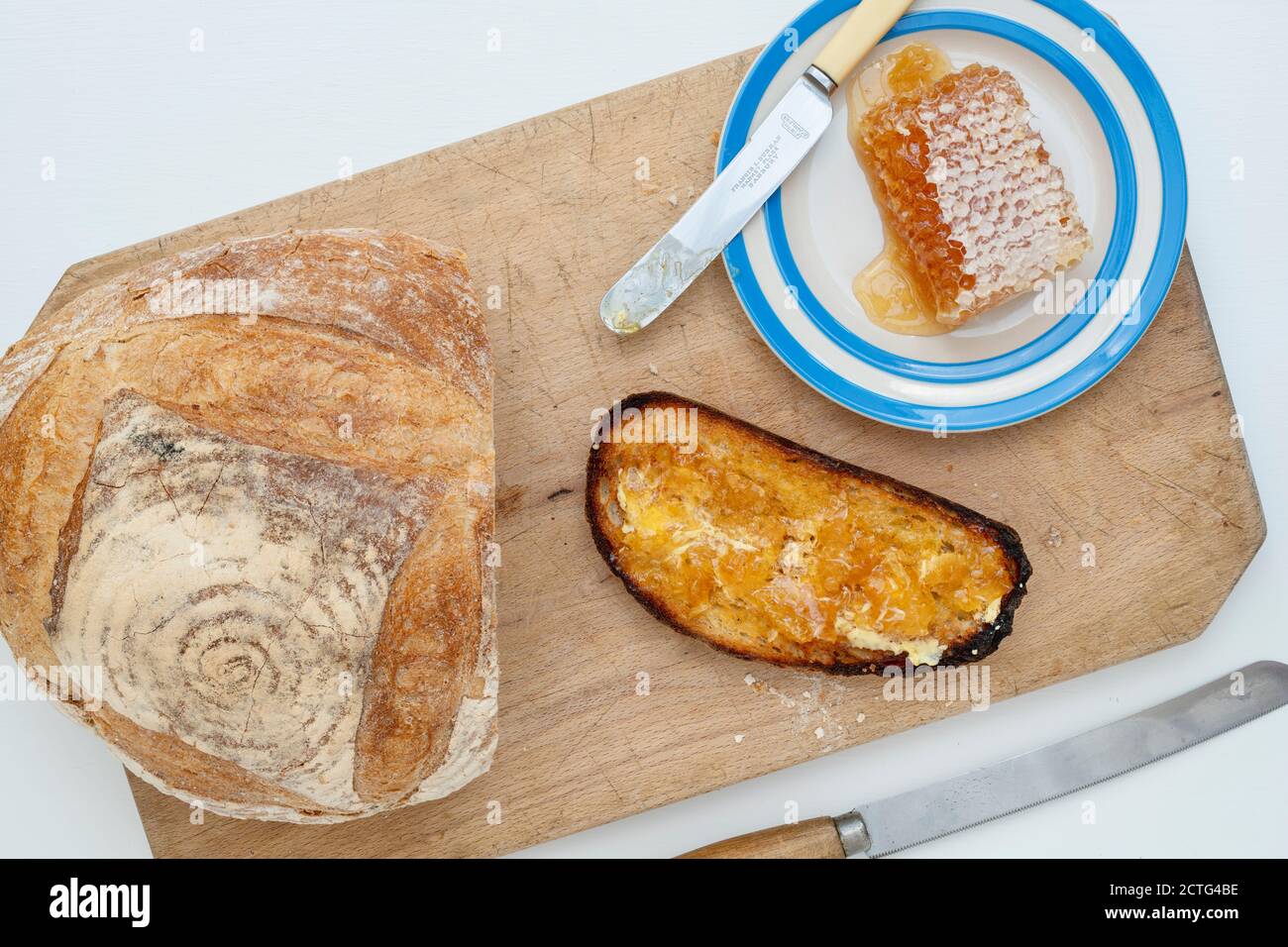 Pain grillé au levain avec nid d'abeille sur une planche à pain. ROYAUME-UNI Banque D'Images
