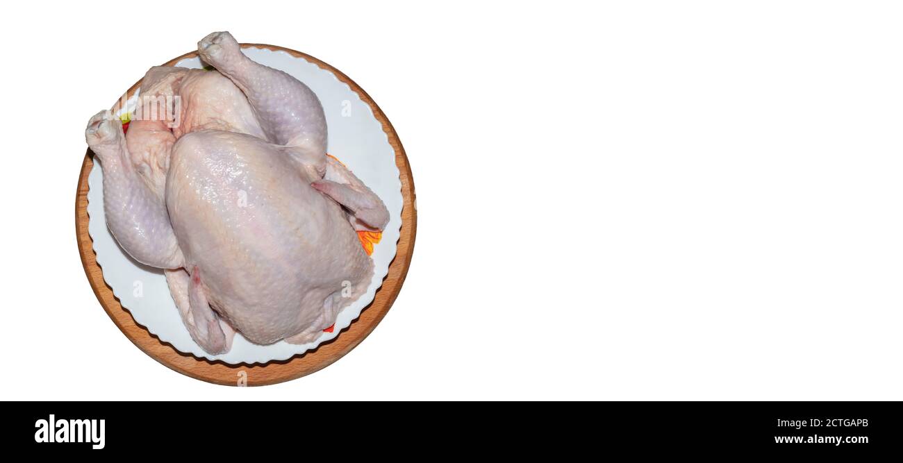Un gros plan d'un poulet entier sur une assiette et une planche en bois. Isolé sur fond blanc avec espace de copie. Taille du panorama. Banque D'Images