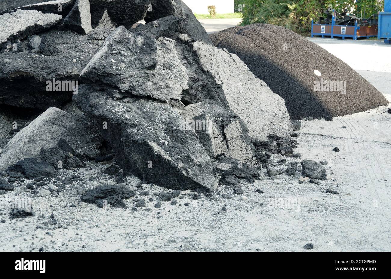 Des grosses pièces cassées de revêtement d'asphalte endommagé et des pierres concassées de l'ancienne route formant des gravats comme un processus de renouvellement de l'allée. Banque D'Images
