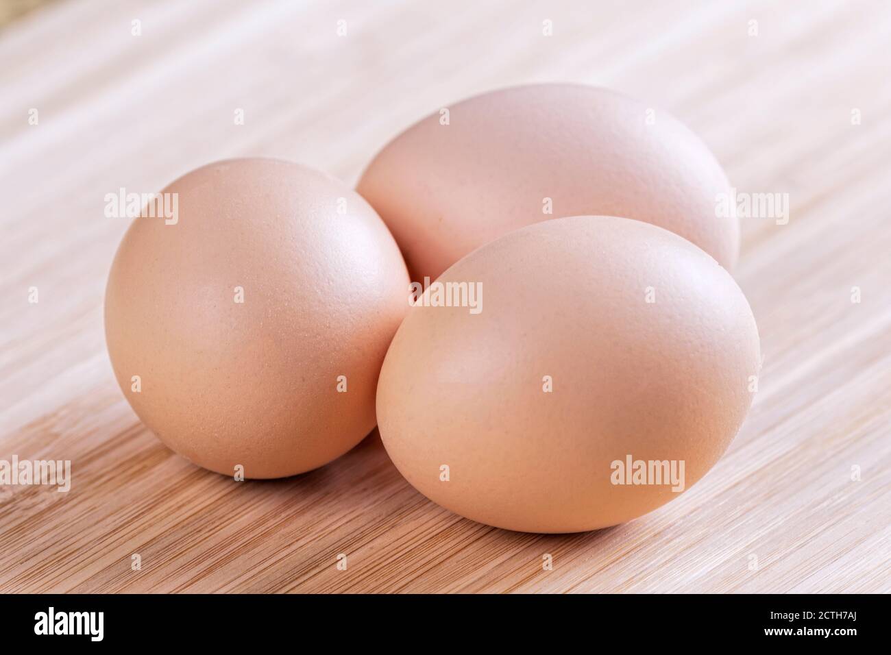 Un fond de ferme des oeufs bruns frais sur un bois planche à découper Banque D'Images