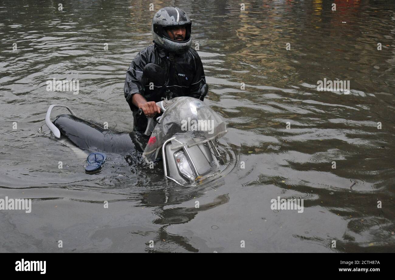 Mumbai, Inde. 23 septembre 2020. Un homme pousse son vélo à travers une route en eau.de fortes pluies ont heurté la ville résultant en l'engorgement et les gens ayant de la difficulté à faire à travers les eaux inondées. Crédit : SOPA Images Limited/Alamy Live News Banque D'Images