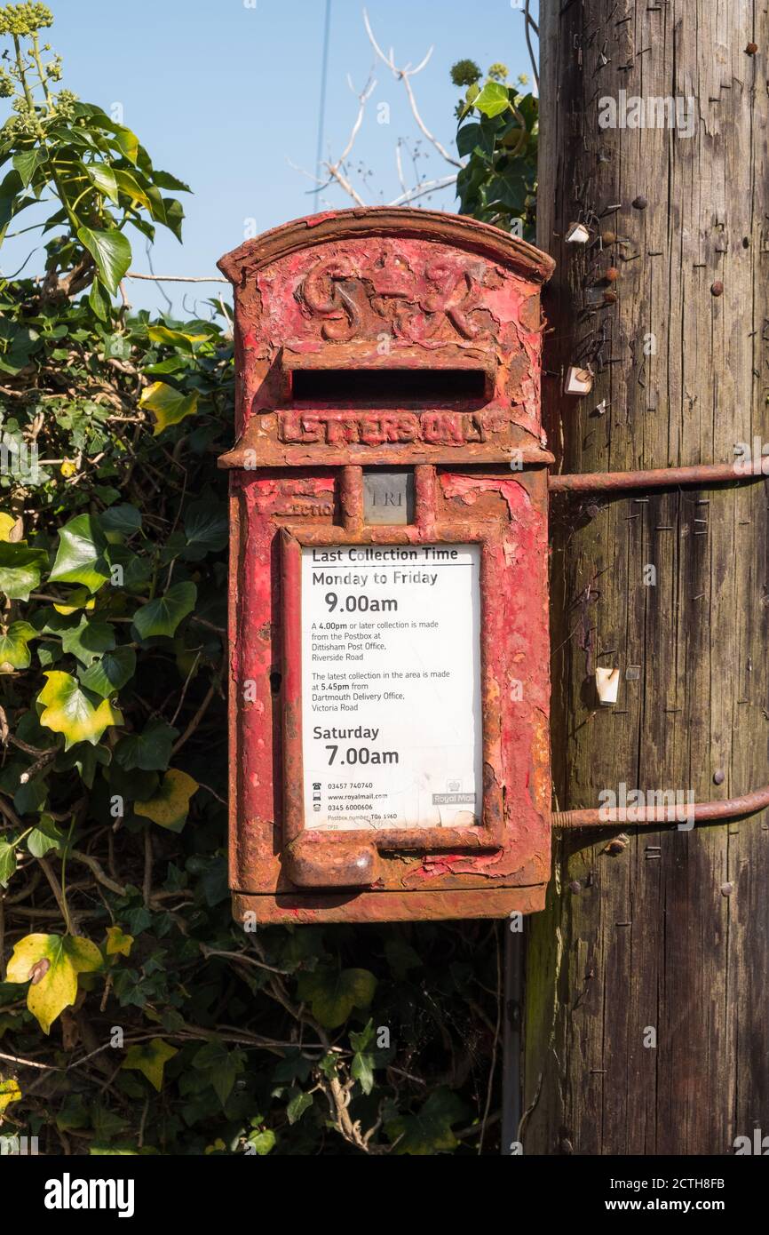 Boîte postale Royal Mail rouillée très ancienne montée sur un poteau télégraphique en bois à Dittisham, devon, Royaume-Uni Banque D'Images