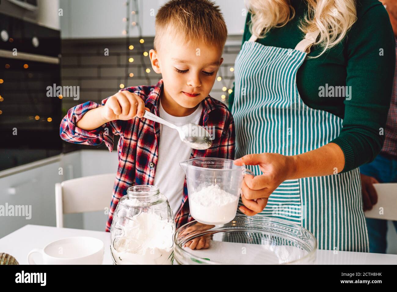 Un garçon et une mère non reconnue cuisinent ensemble dans la cuisine le réveillon de Noël. Banque D'Images