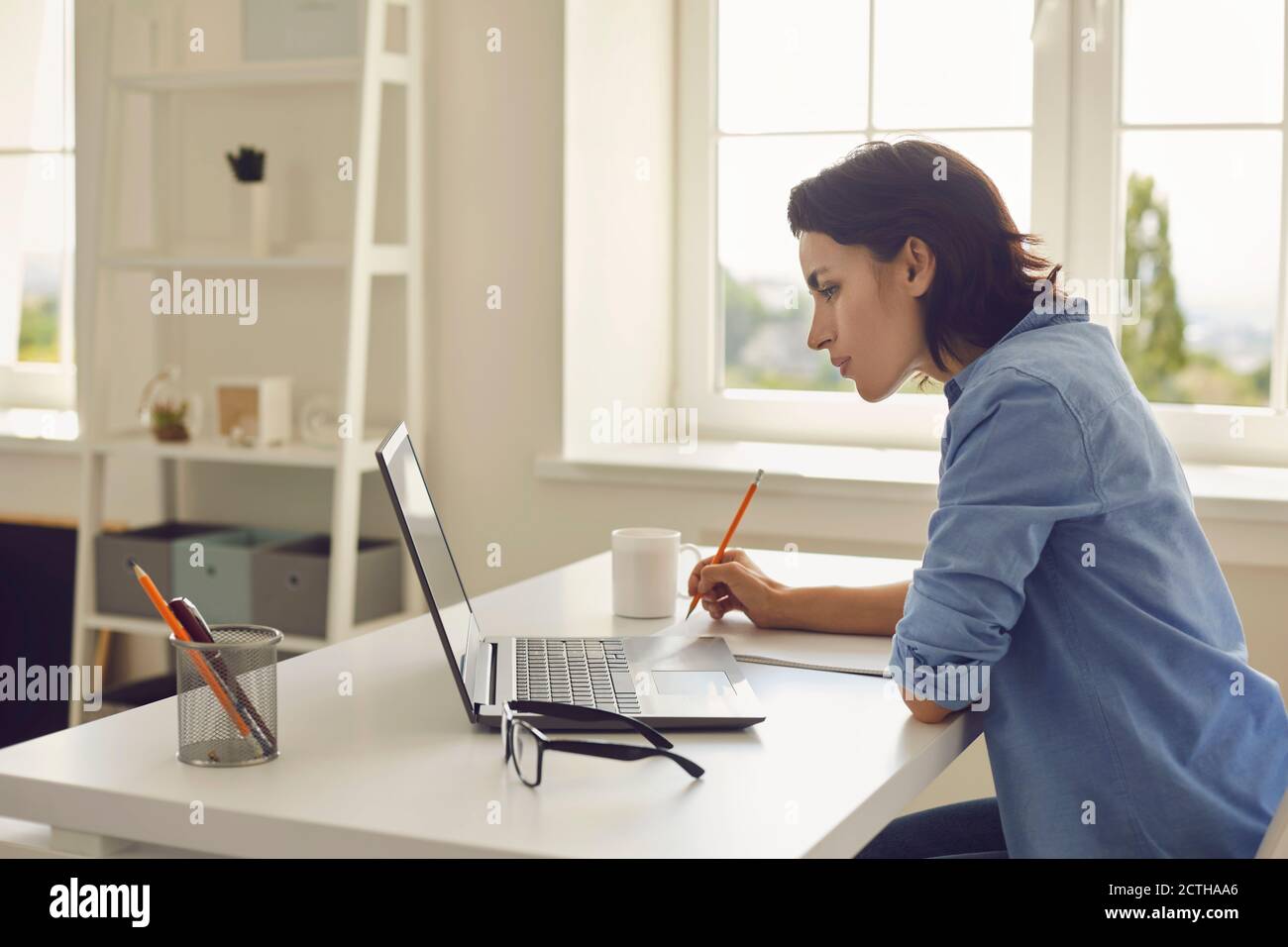 Femme écoutant quelqu'un pendant une leçon en ligne ou une conférence Banque D'Images