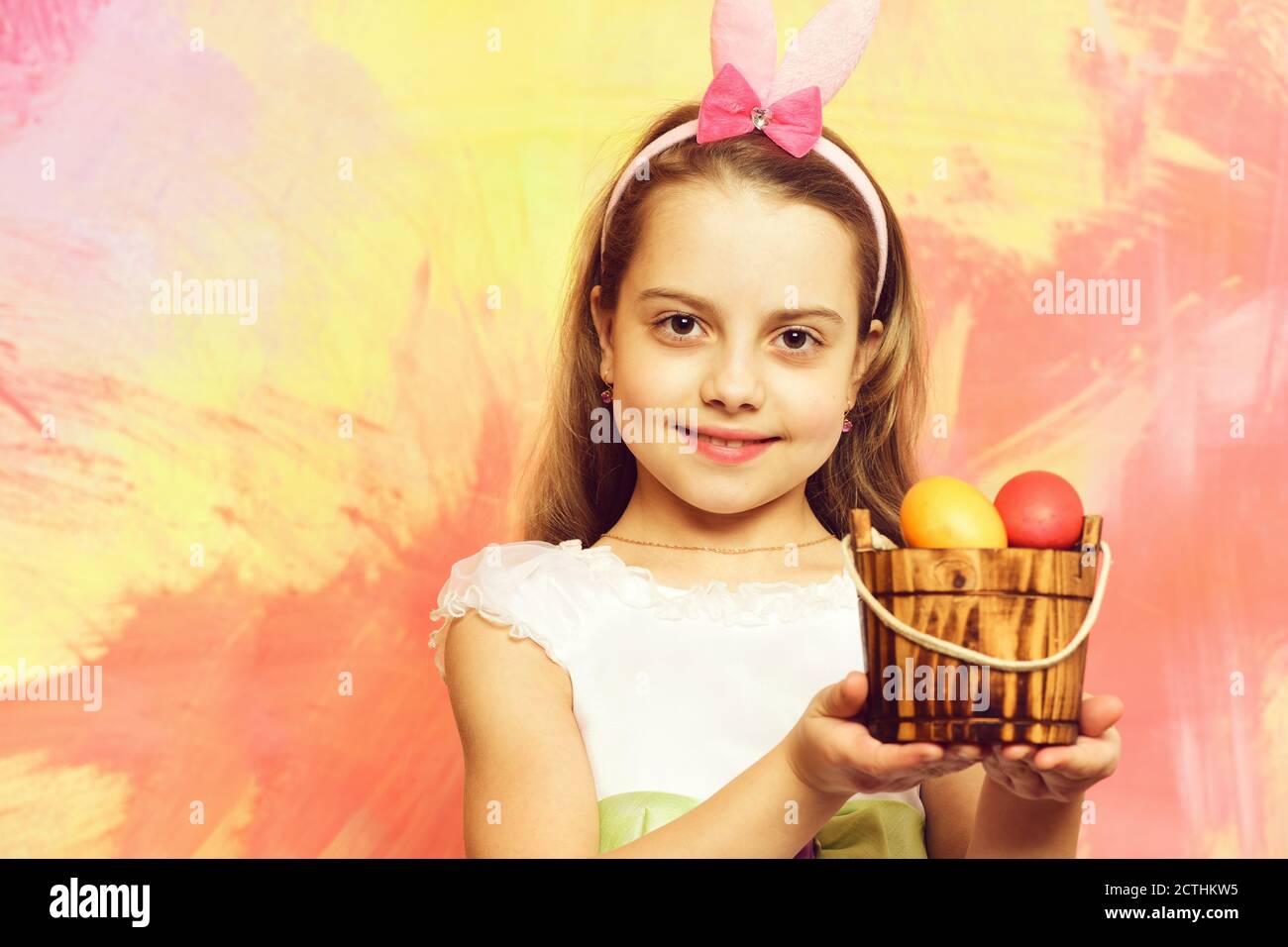 Petit bébé fille ou enfant mignon visage heureux et avec des cheveux blonds  en robe blanche tenant avec des oeufs de Pâques colorés sur fond de texture  Photo Stock - Alamy