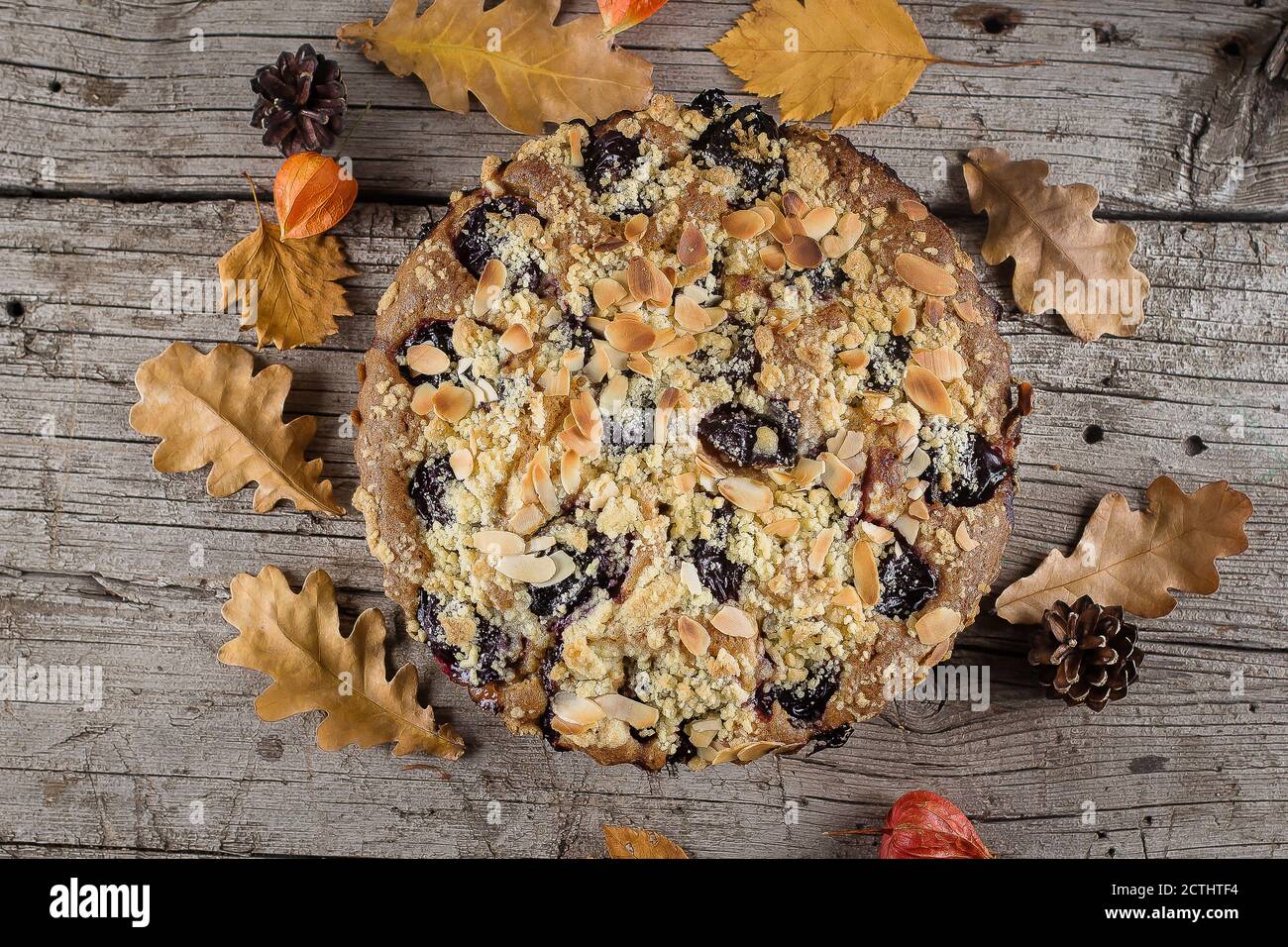 Cuisine d'automne confortable. Gâteau d'automne maison avec noix et prunes sur fond de bois, vue de dessus, espace copie. Banque D'Images