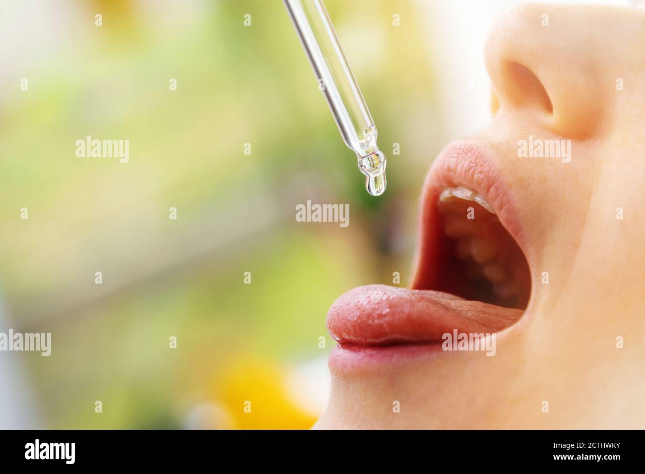 femme prenant des gouttes de vitamine dans la bouche de dropper. copier l'espace Banque D'Images