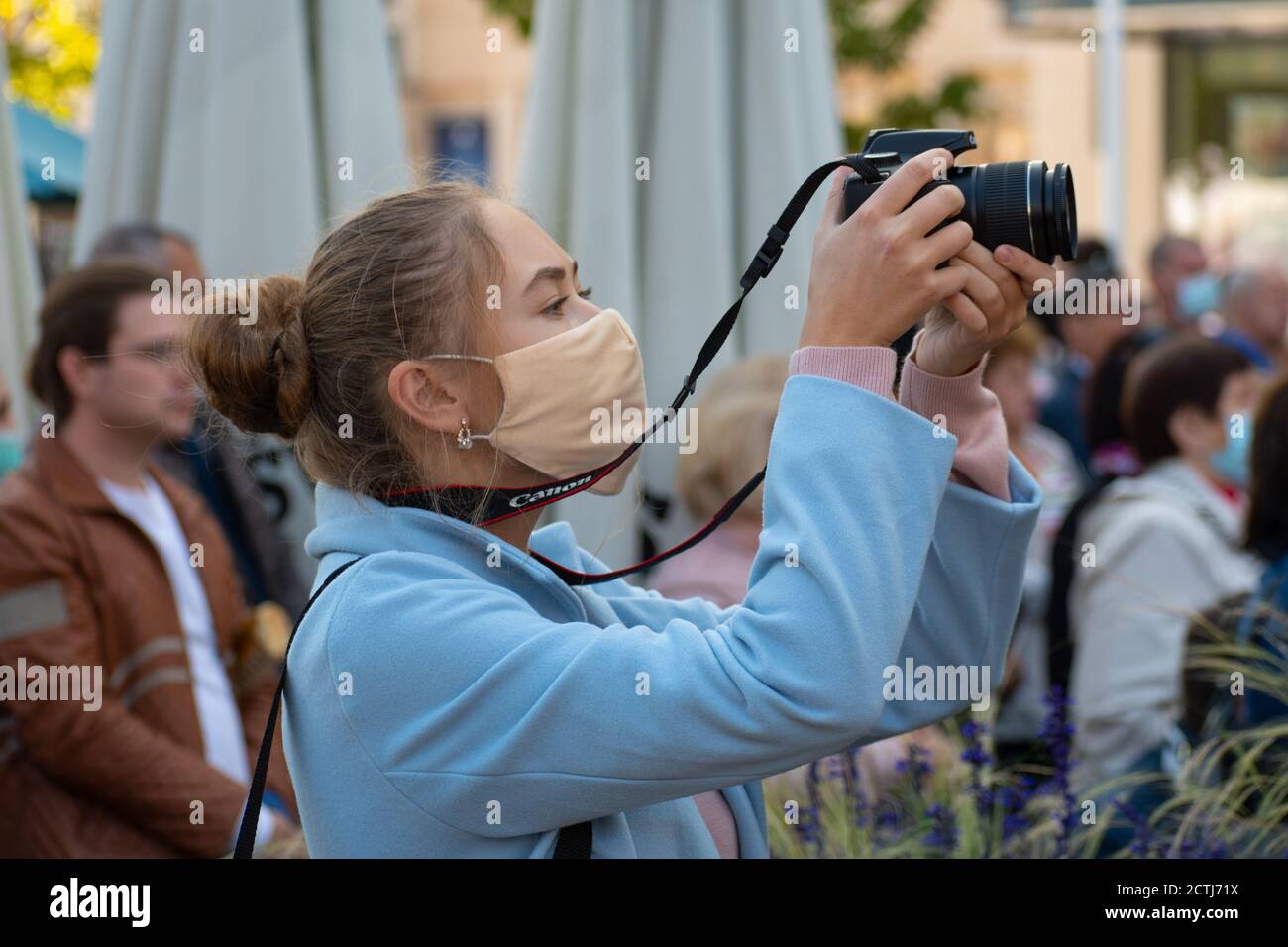 Belle fille avec masque prendre des photos avec l'appareil photo pendant l'épidémie de Covid ou de coronavirus dans un événement public, festival de musique, concert Banque D'Images
