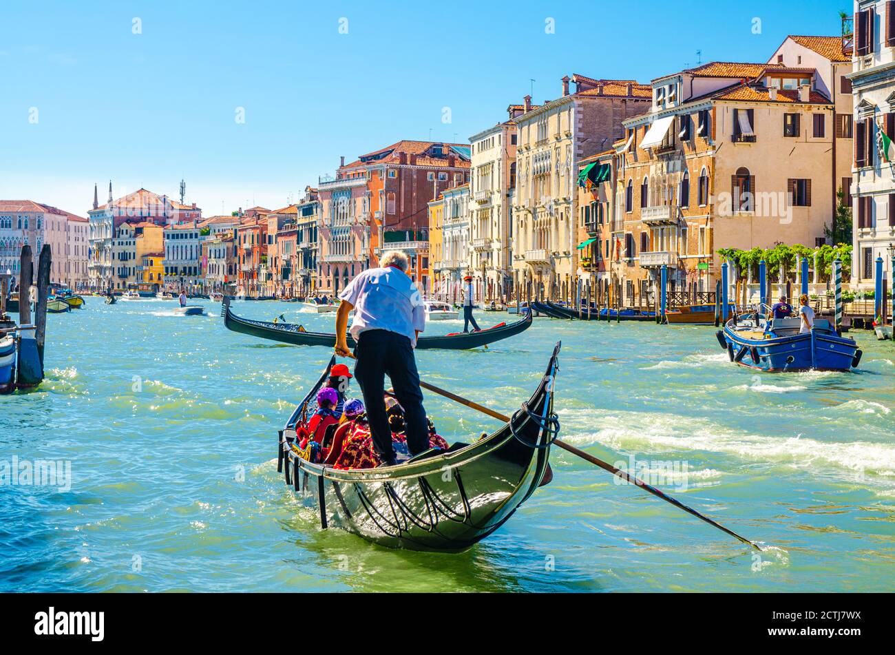 Venise, Italie, 13 septembre 2019 : gondolier et touristes en gondole bateau traditionnel naviguant sur l'eau du Grand Canal avec architecture vénitienne typique bâtiments colorés arrière-plan Banque D'Images