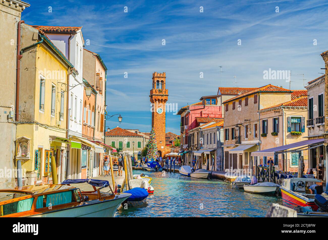 Îles de Murano avec tour d'horloge Torre dell'Orologio, bateaux et bateaux à moteur dans le canal d'eau, bâtiments traditionnels colorés, lagune vénitienne, région de Vénétie, Italie du Nord. Carte postale de Murano. Banque D'Images