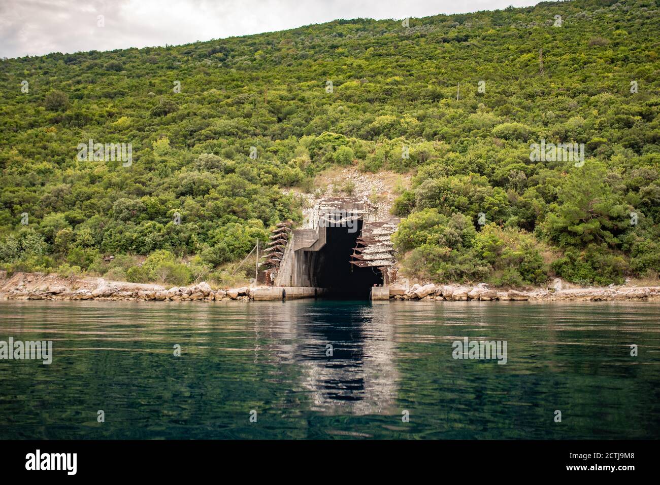 Entrée à l'abri sous-marin abandonné, la baie de Kotor, la mer Adriatique, Monténégro. Péninsule de Lustica Rose village. Banque D'Images