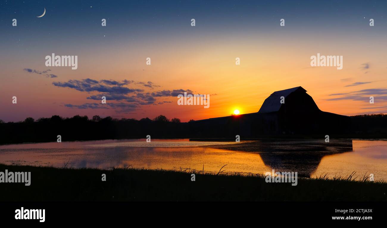 Ancienne Grange et coucher de soleil reflétés dans l'eau Banque D'Images