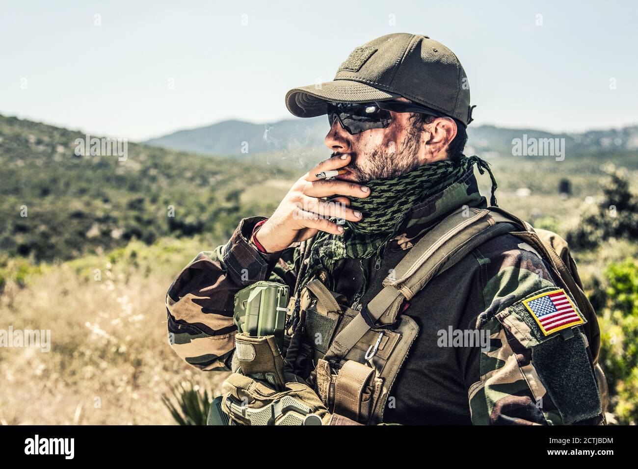 Soldat des forces spéciales de l'armée, chasse aux phoques en uniforme de  camouflage, foulard à sorbade, lunettes et casquette balistiques,  porte-plaque tactique, fumage de cigarettes, repos après le combat dans la  région