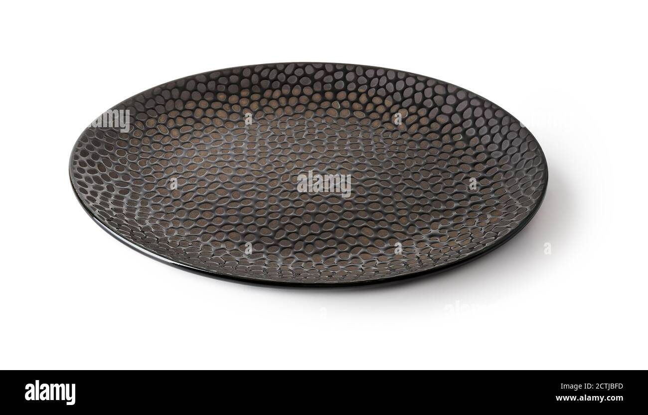 Vue latérale d'une plaque ronde en céramique noire avec surface texturée isolée sur un fond blanc. Vaisselle vide pour la conception des aliments. Argile et céramique modernes. Banque D'Images