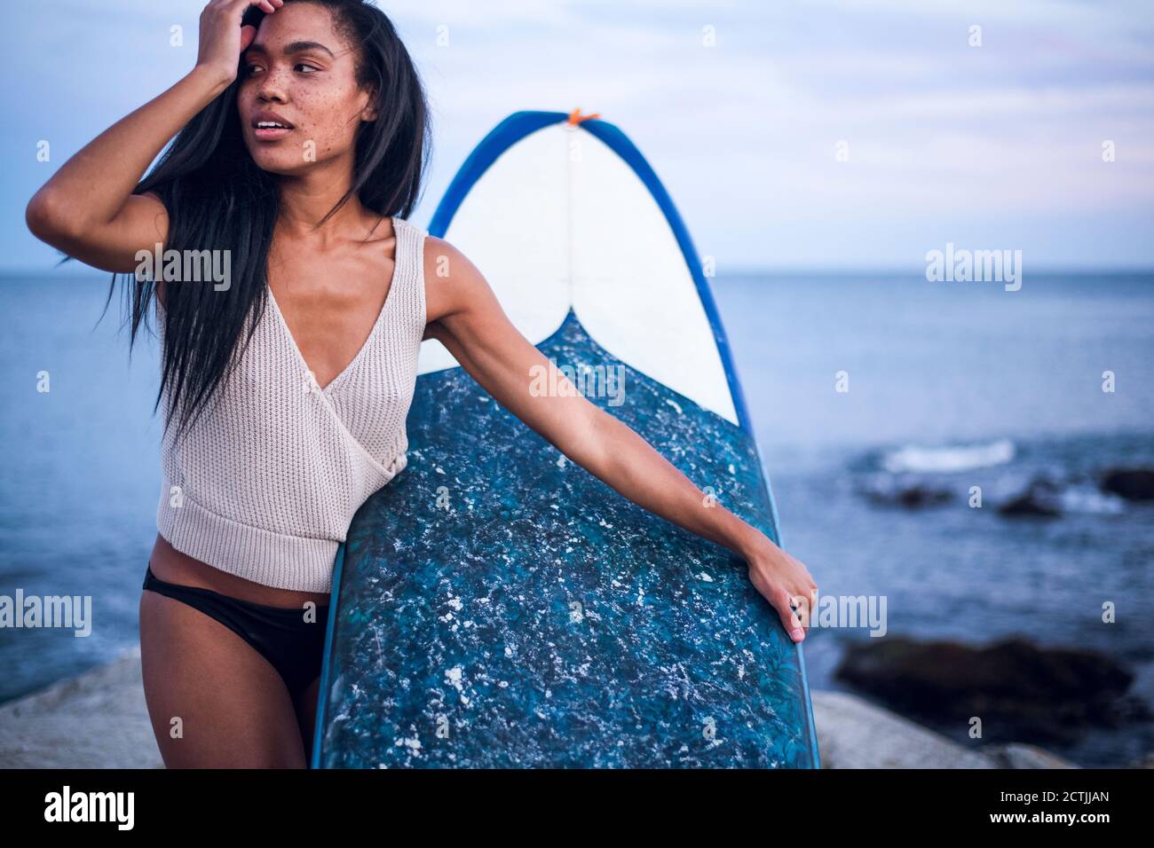 Portrait de style de vie de femme noire multiraciale au bord de l'océan avec planche de surf Banque D'Images